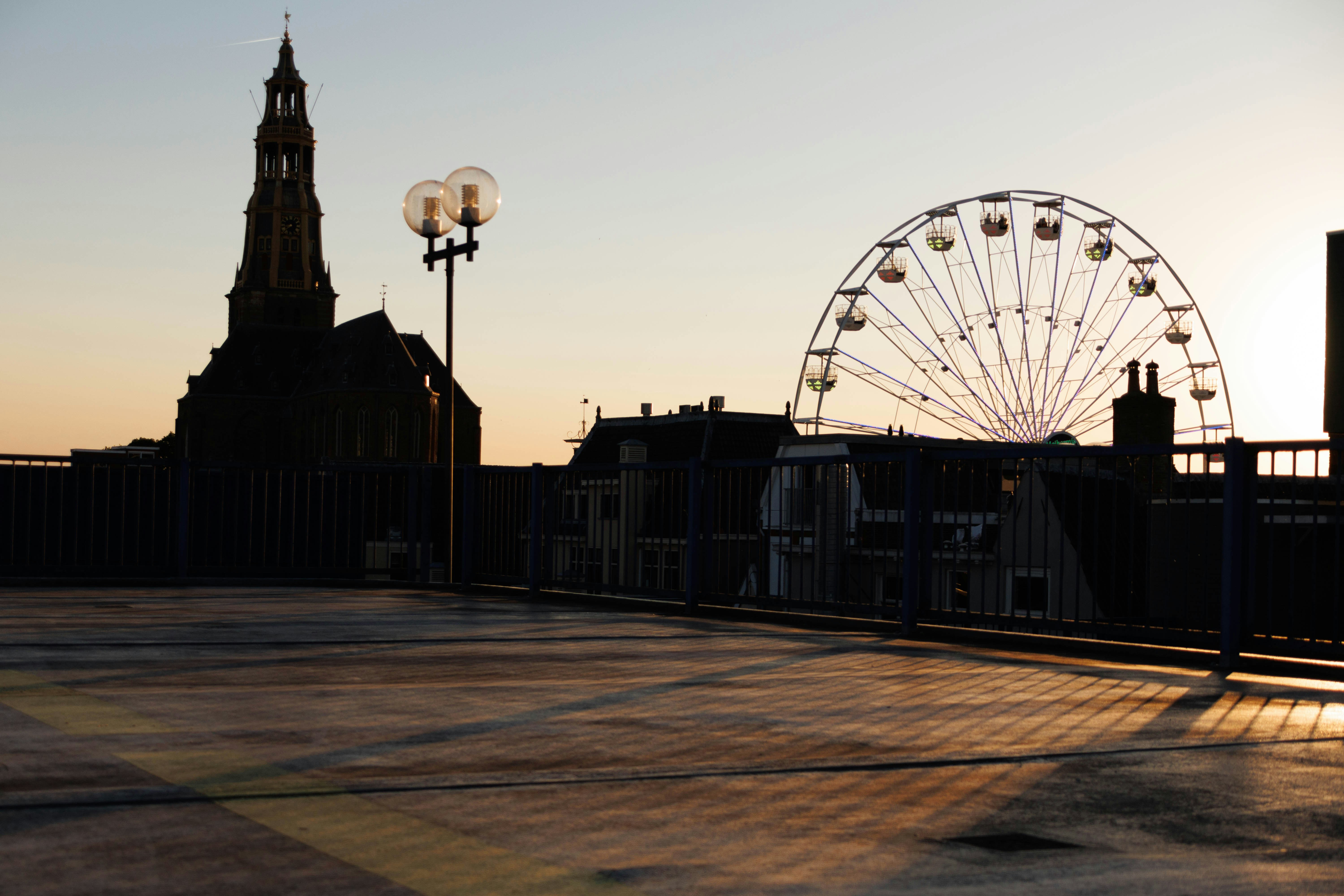 高いビルの隣に座っている大きな観覧車