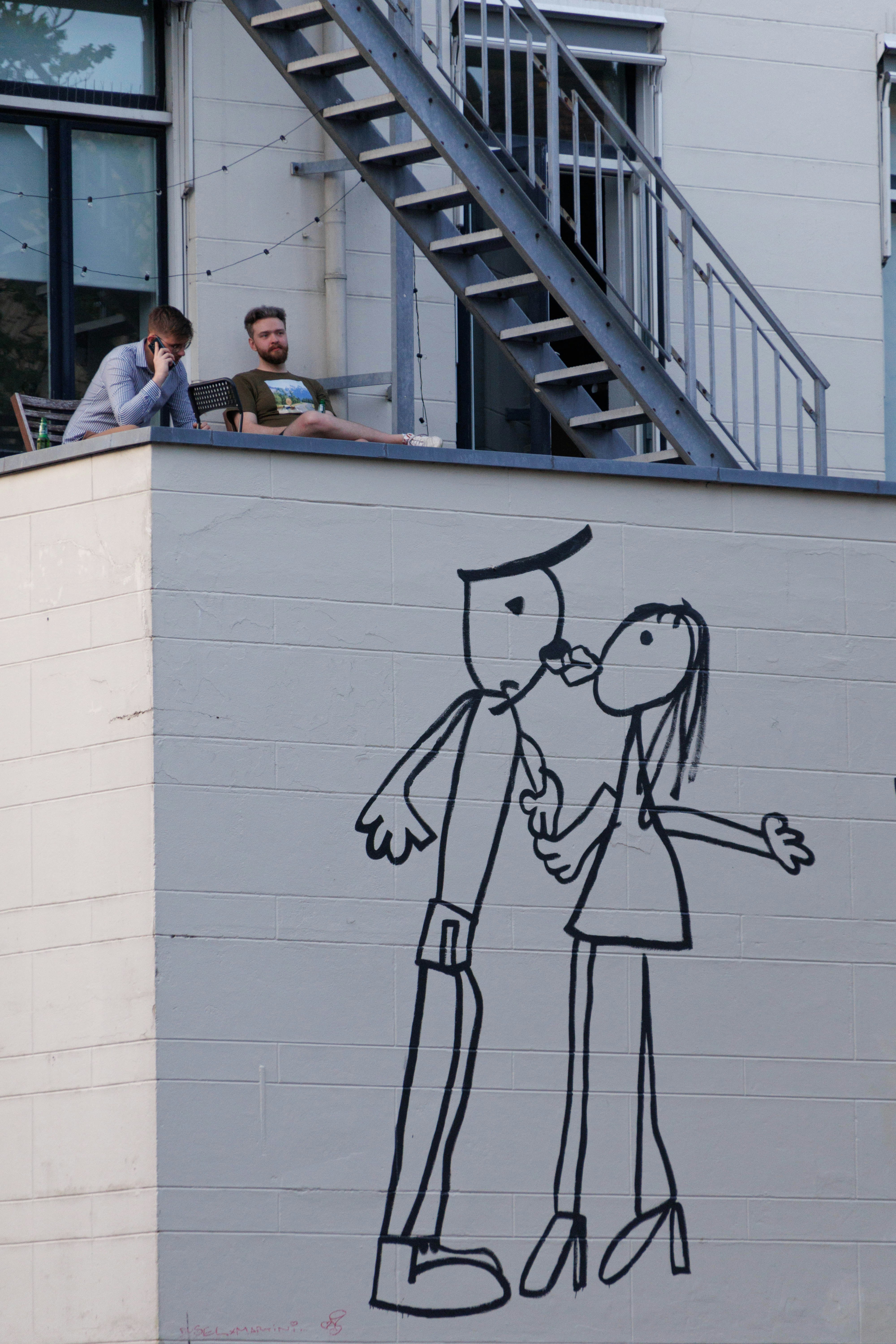 A drawing of a man and a woman kissing on a wall