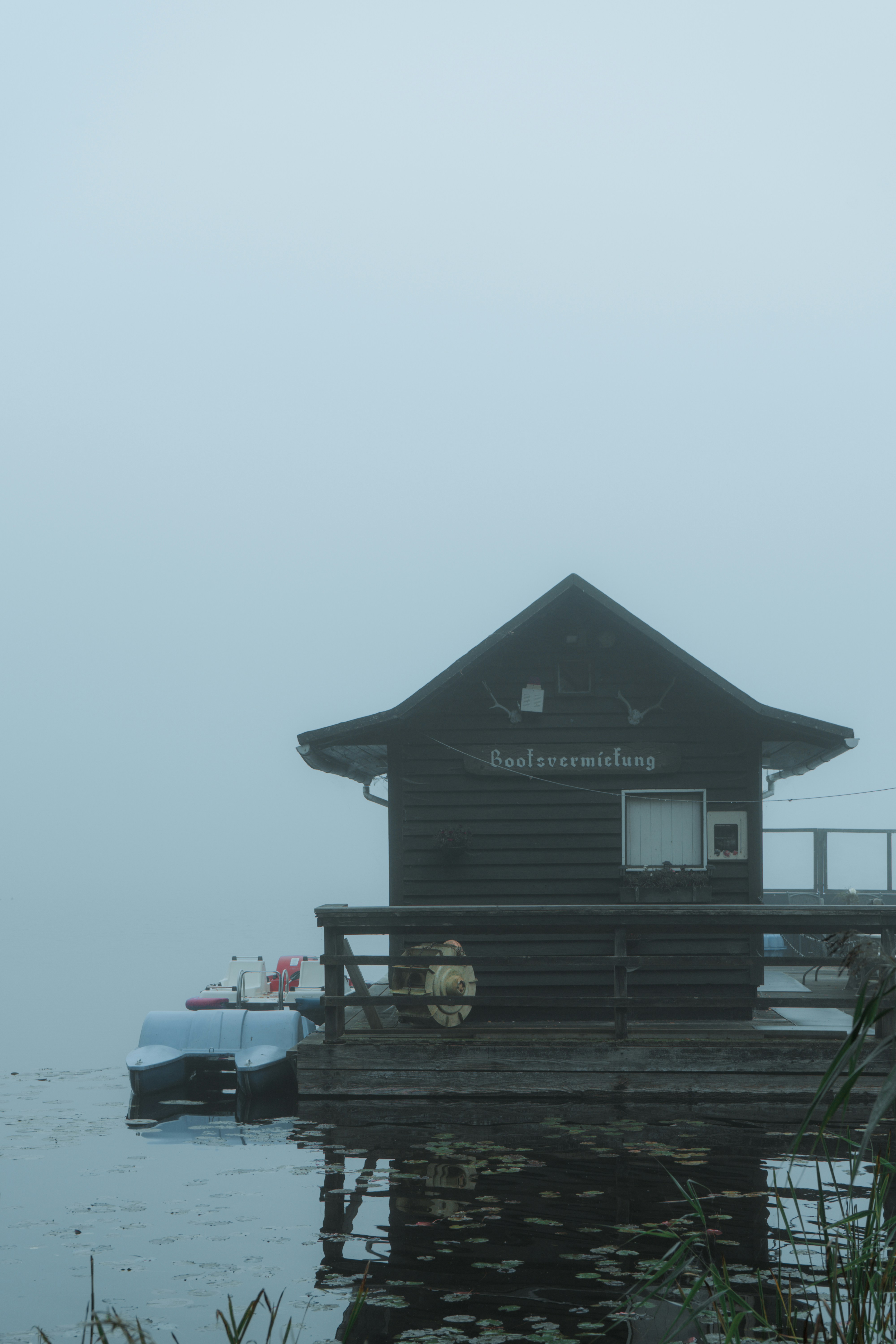 A boat is docked at a dock on a foggy day