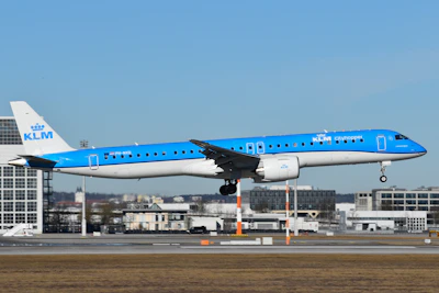 A blue and white jet airliner taking off from an airport runway
