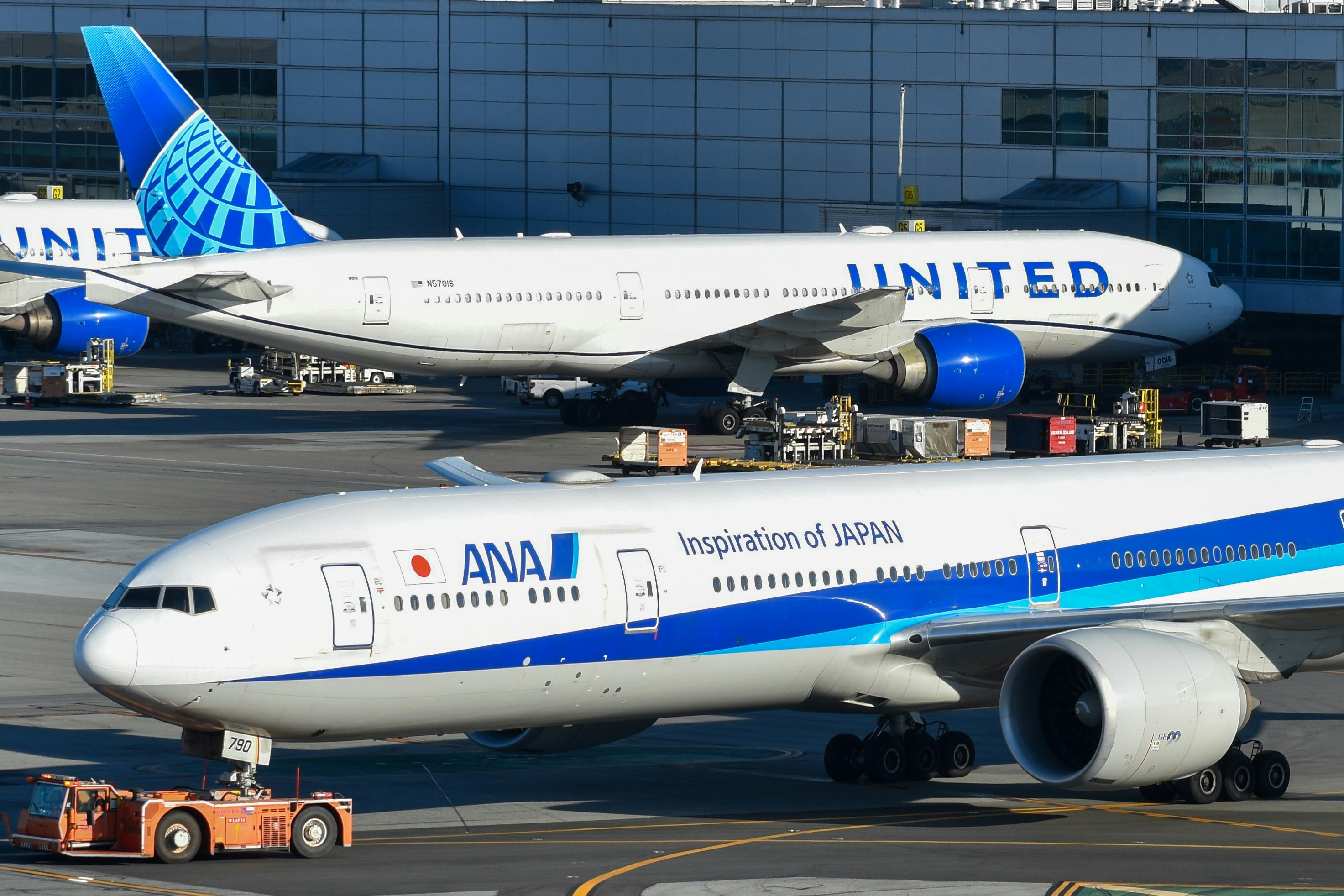 A couple of airplanes that are on a runway, All Nippon Airways and United Airlines 777s at San Francisco International Airport
