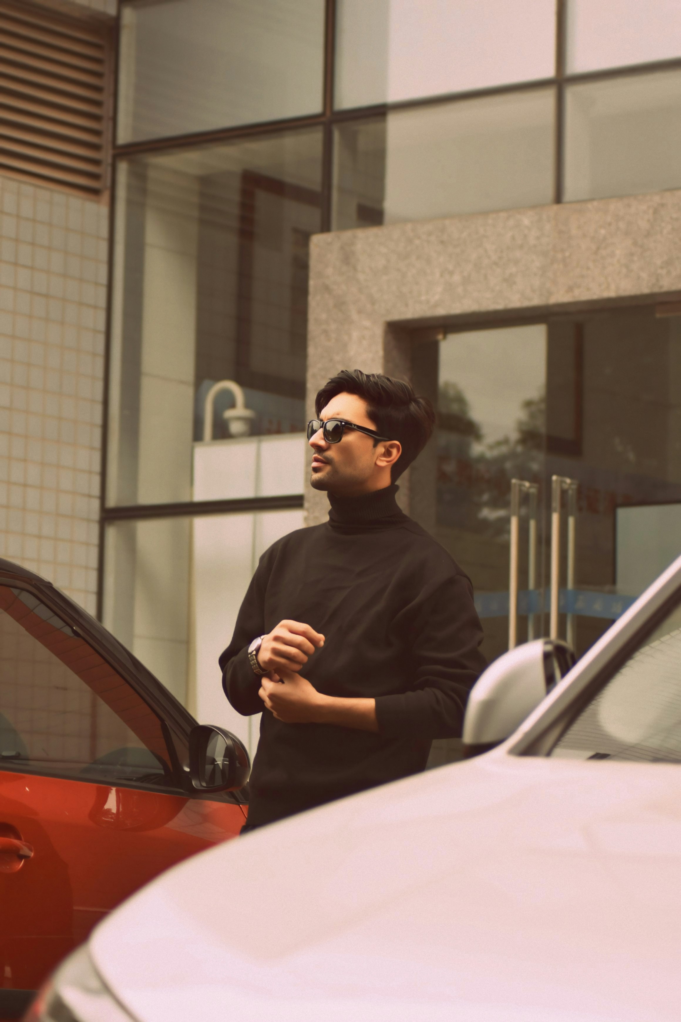 A man standing next to a red car