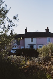A pink house with a car parked in front of it