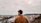 A man standing on top of a hill next to a river