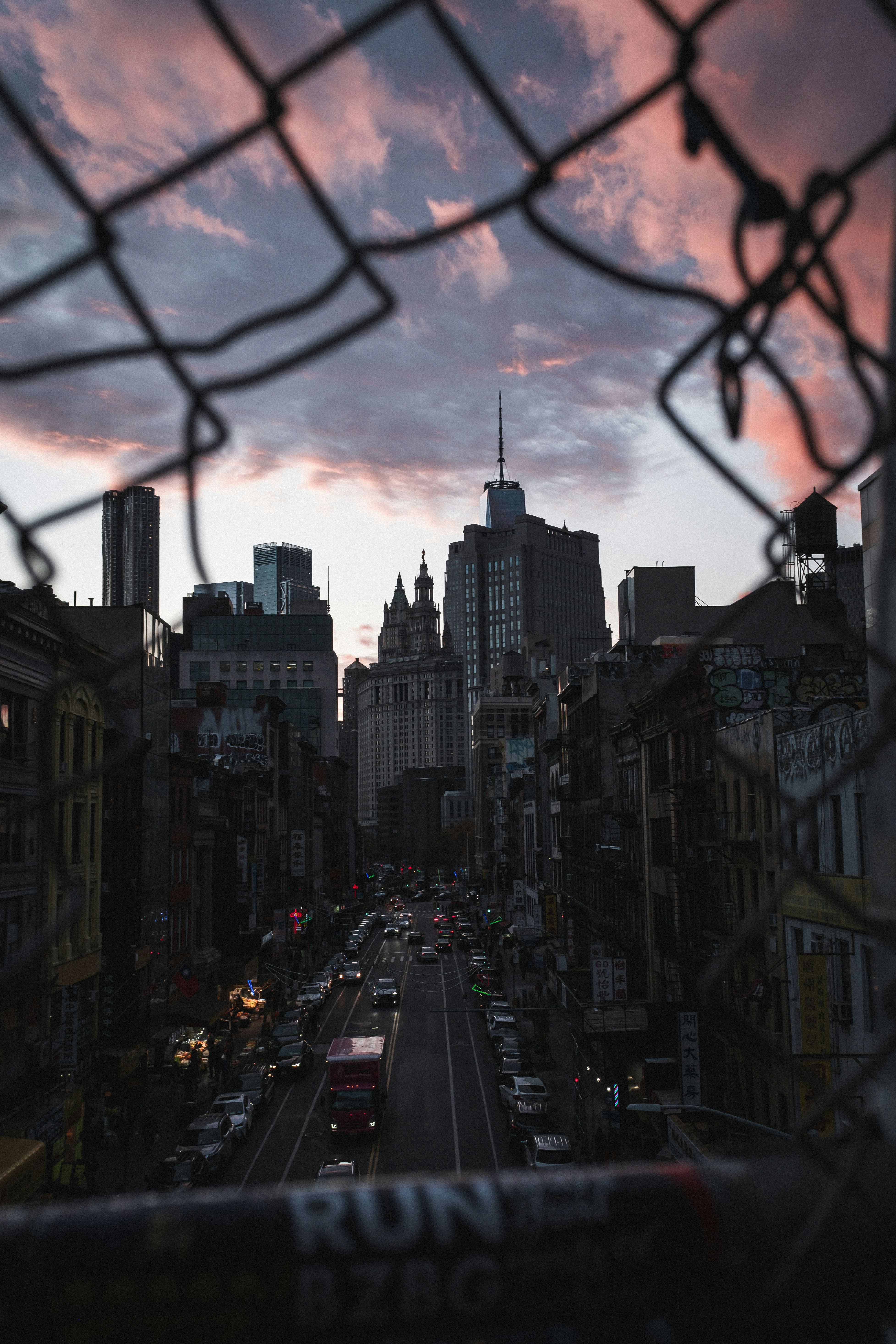 A view of a city from behind a chain link fence