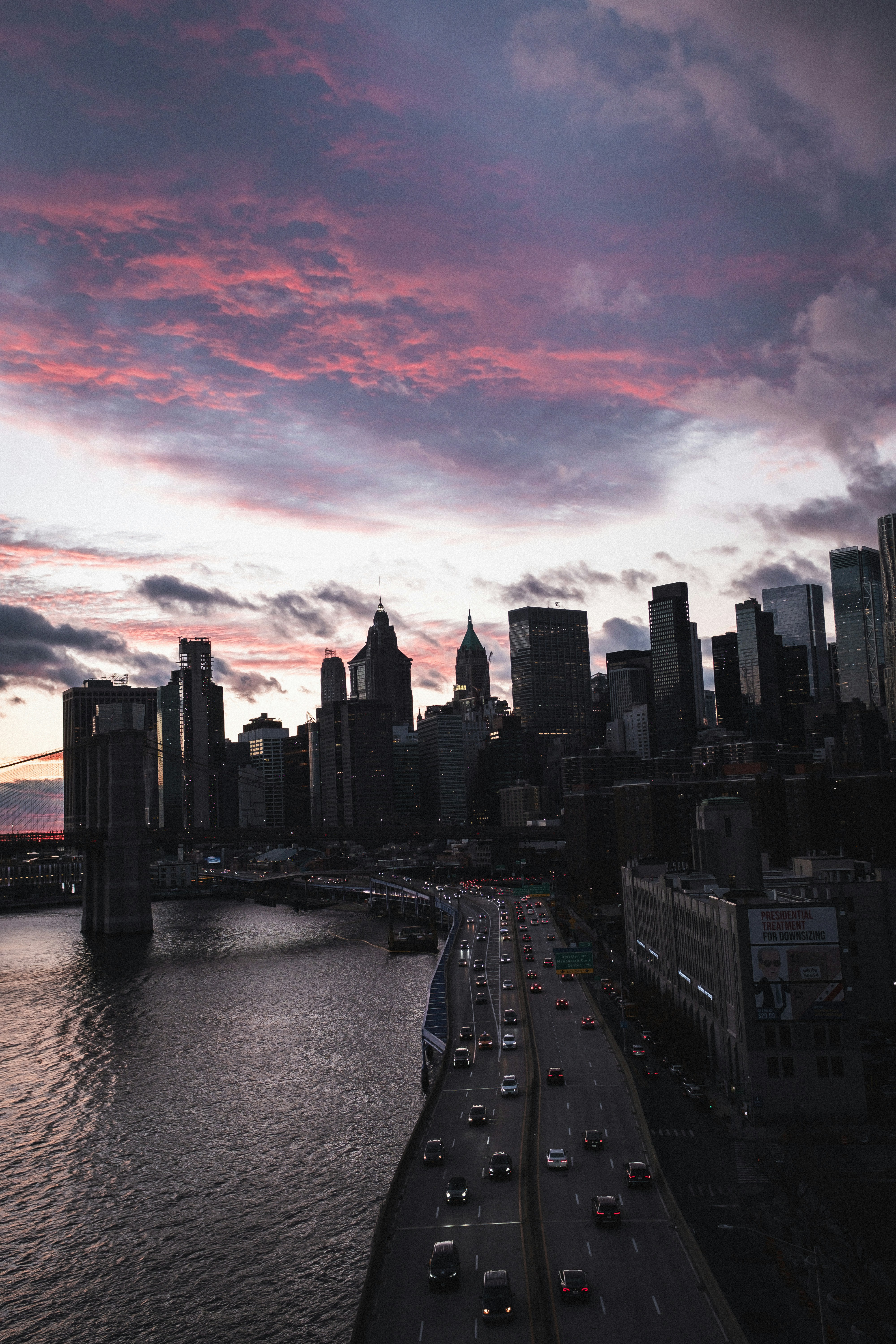 A view of a city at sunset from a bridge