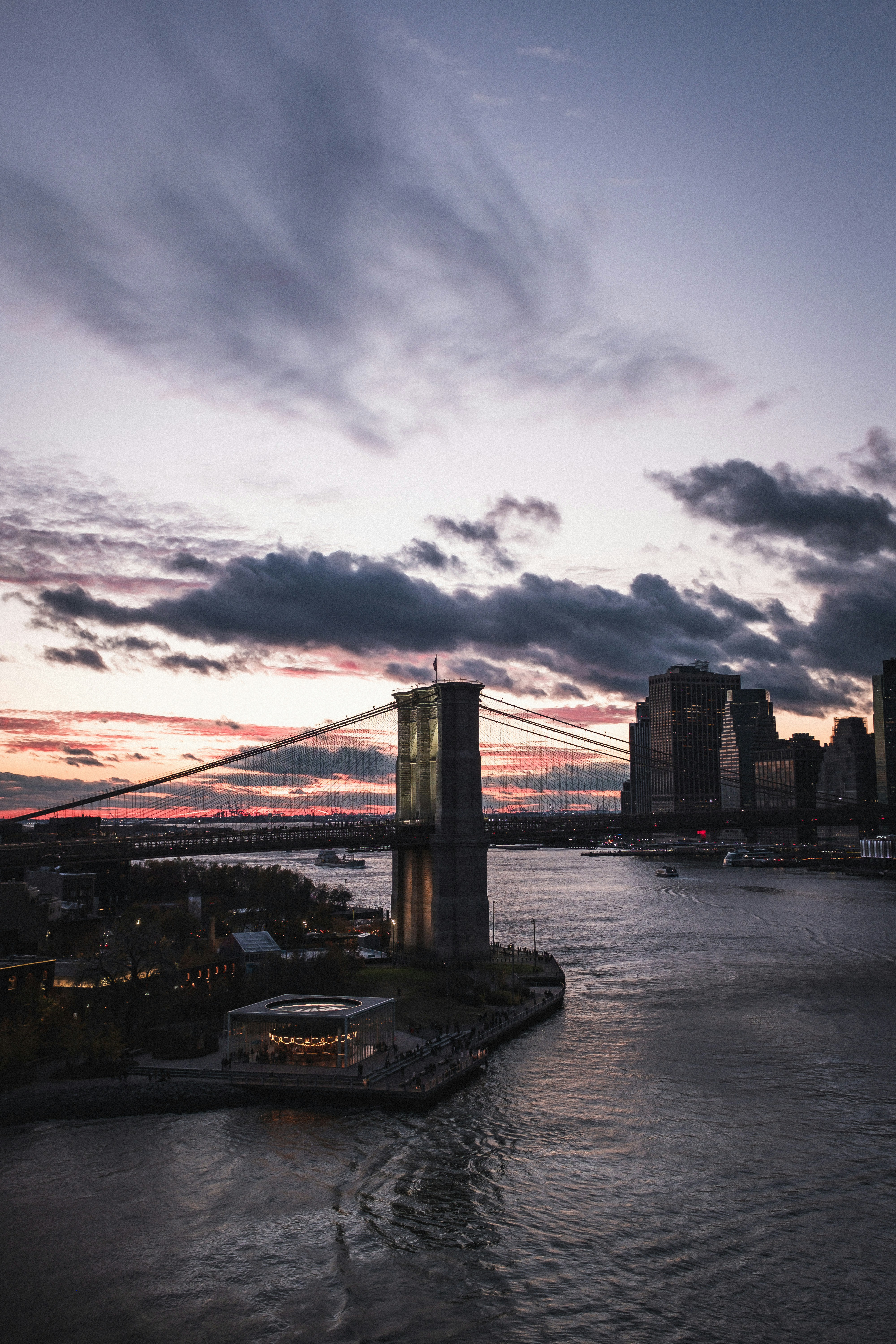 A view of a city and a bridge at sunset