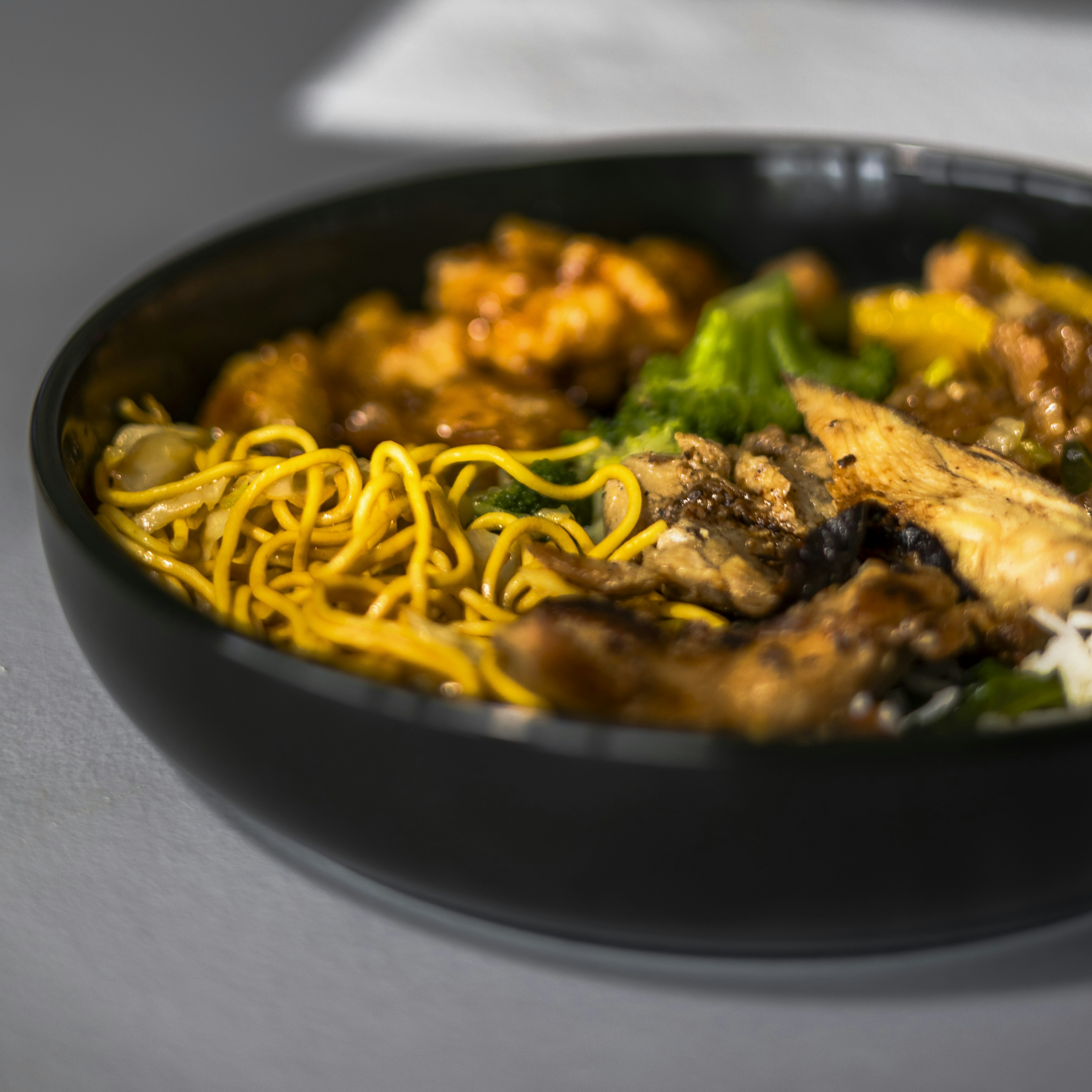 A black bowl filled with food on top of a table