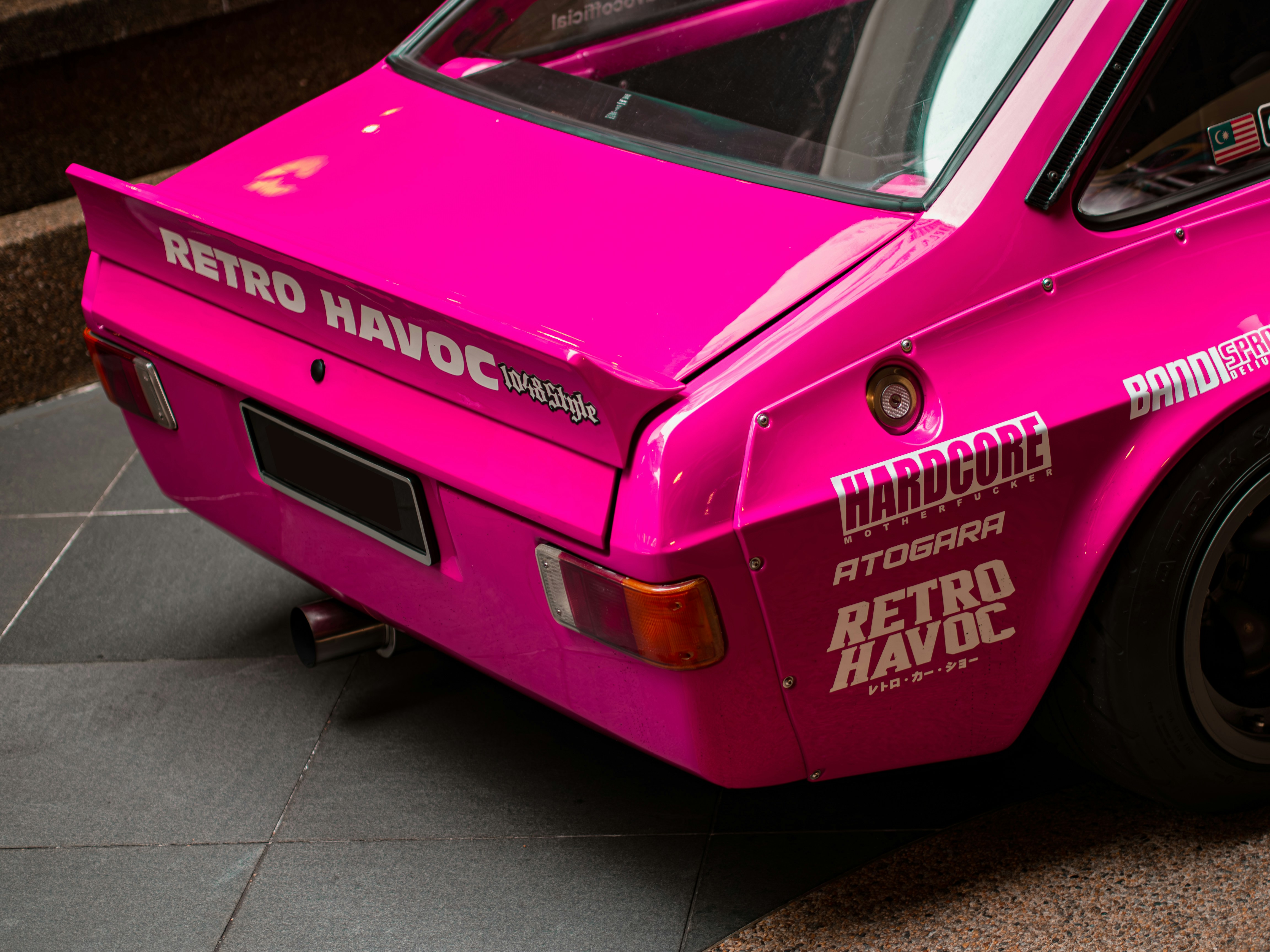 A pink car parked on the side of the road