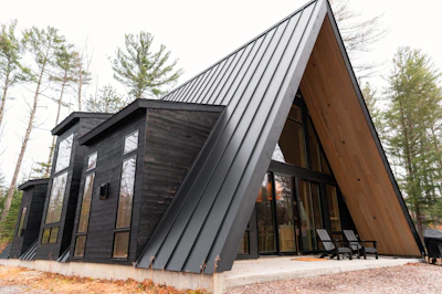 A house with a triangular roof made of wood and metal