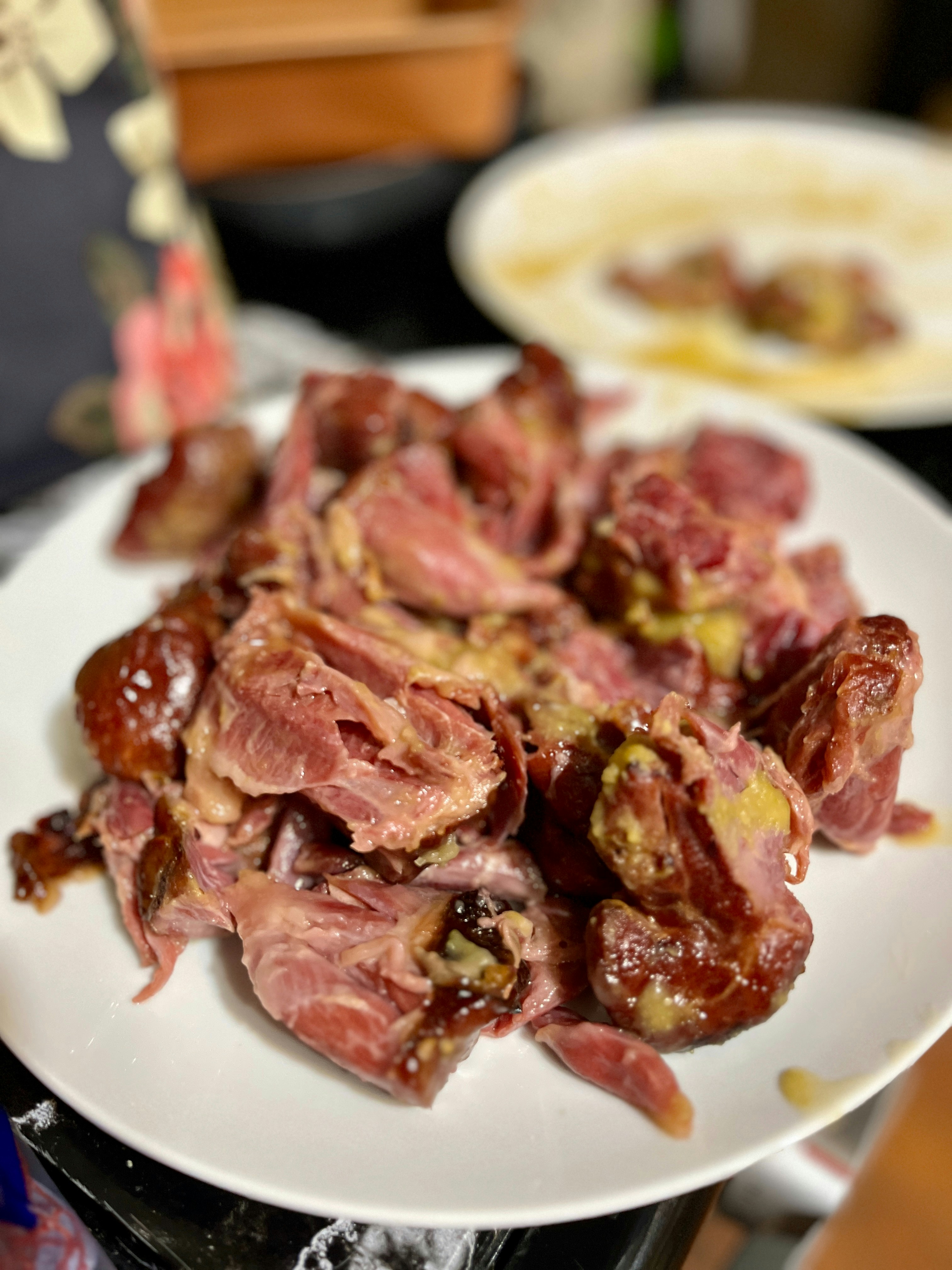 Abon daging berwarna coklat keemasan tersusun rapi di atas piring putih dengan pencahayaan studio yang hangat dan bersih