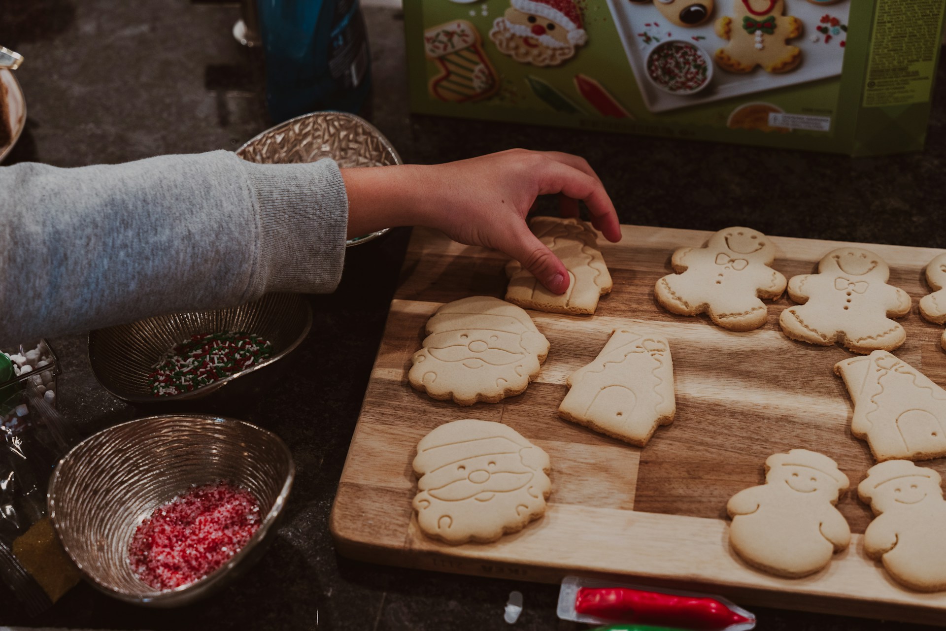 A child is making cookies on a cutting board