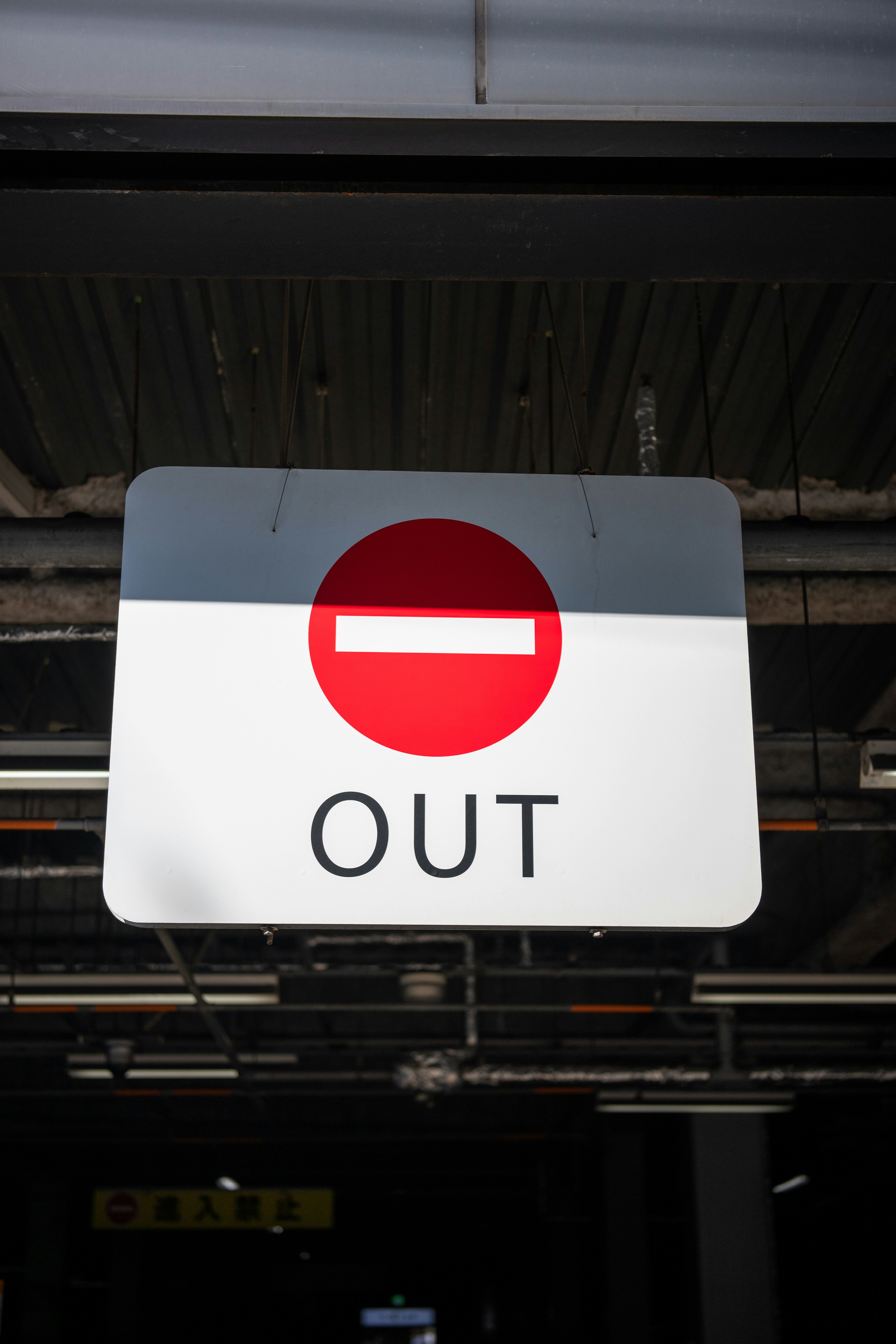 A red and white sign hanging from the side of a building