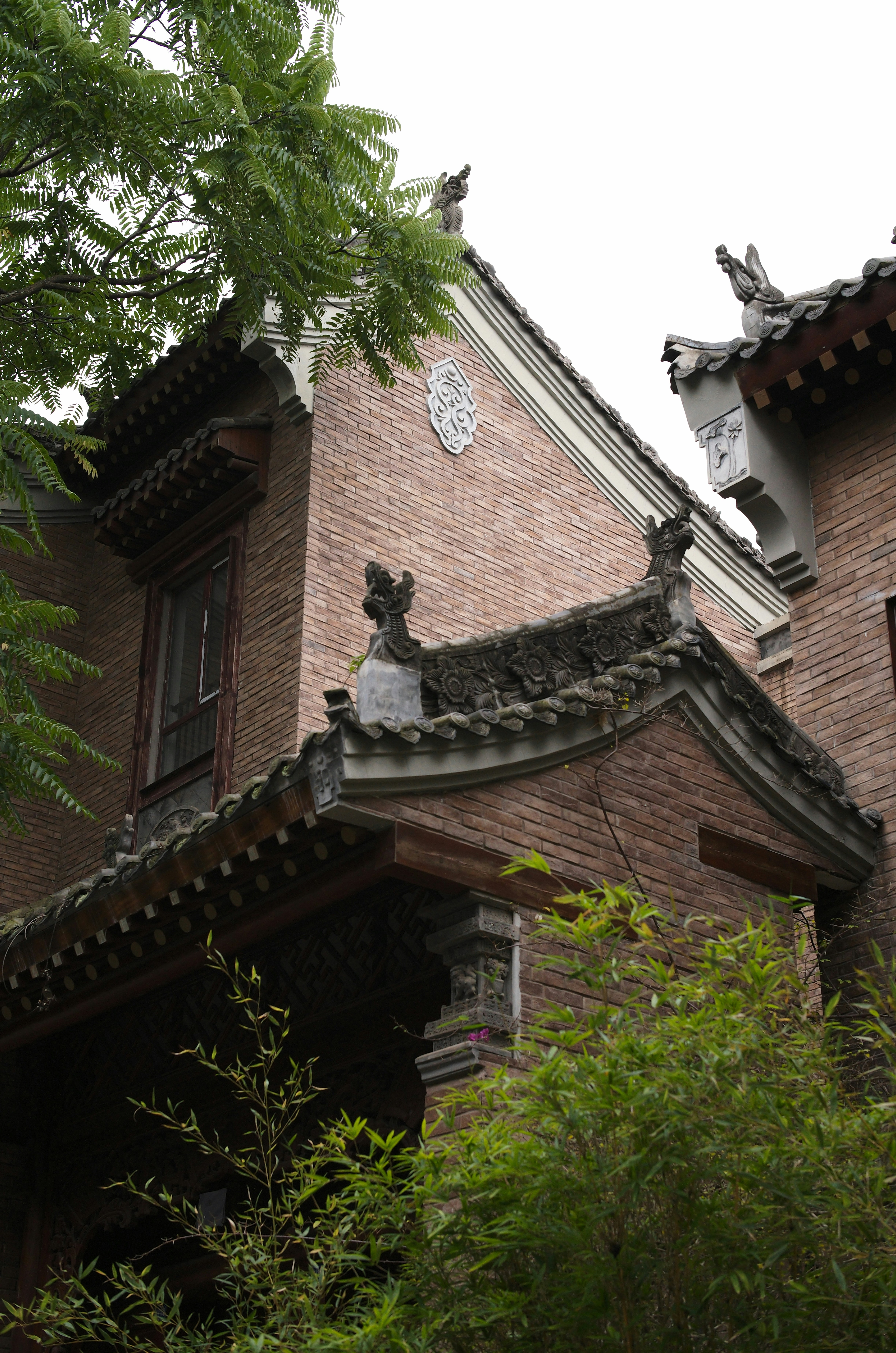 Un alto edificio de ladrillo con un reloj a su lado