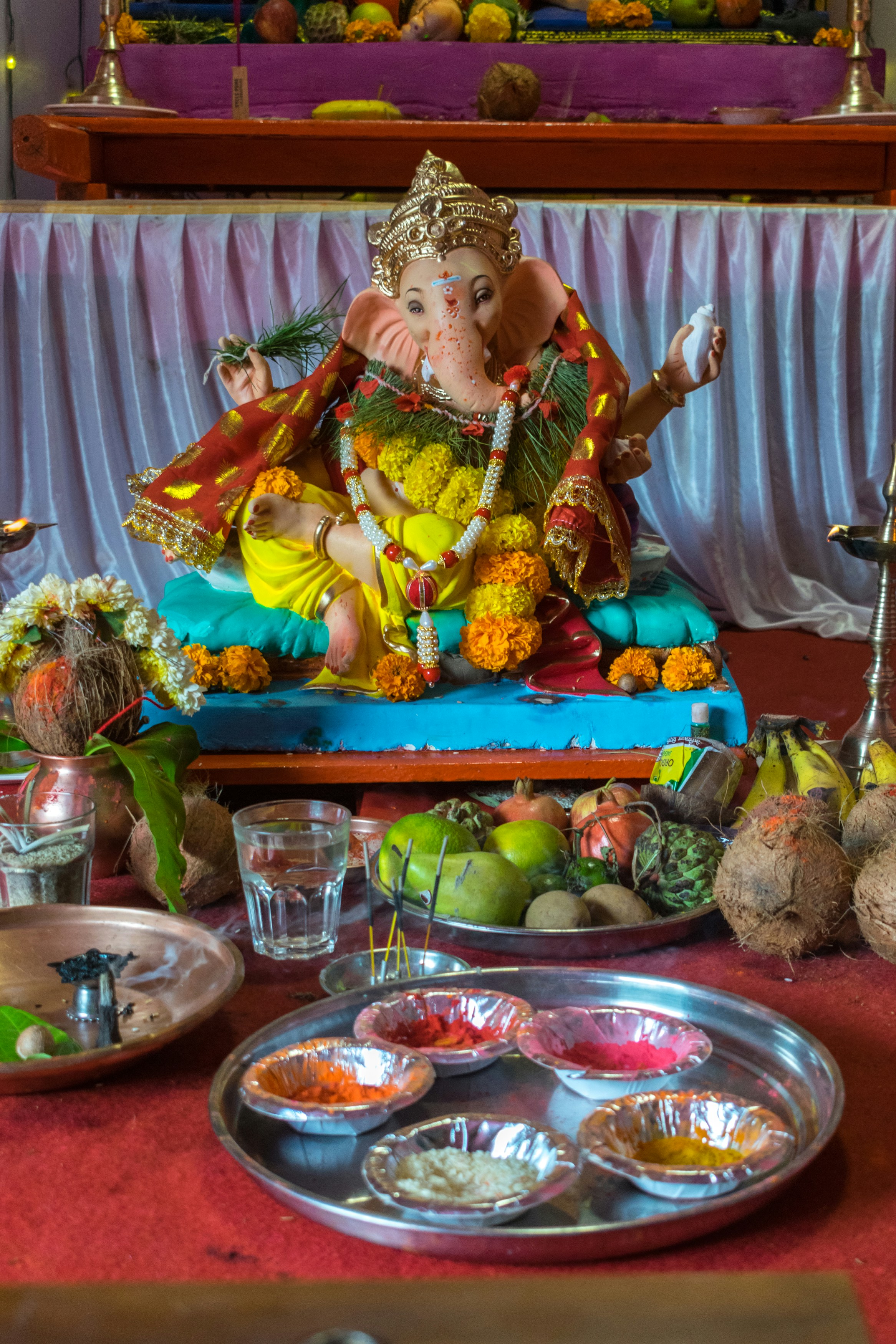 Traditional Ganesh puja ceremony setup with flowers, diyas, and sacred offerings for obstacle removal