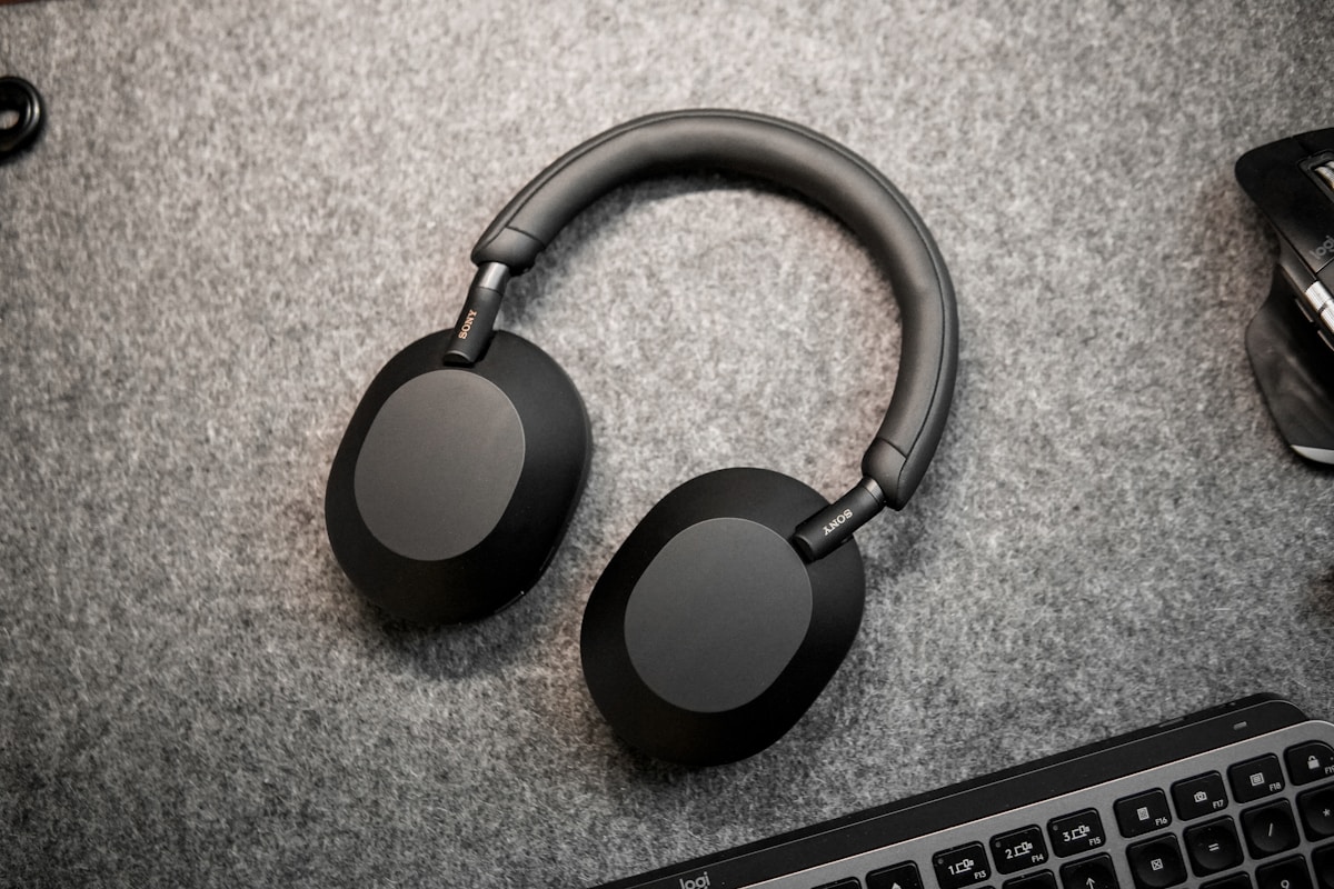 A pair of headphones sitting next to a keyboard