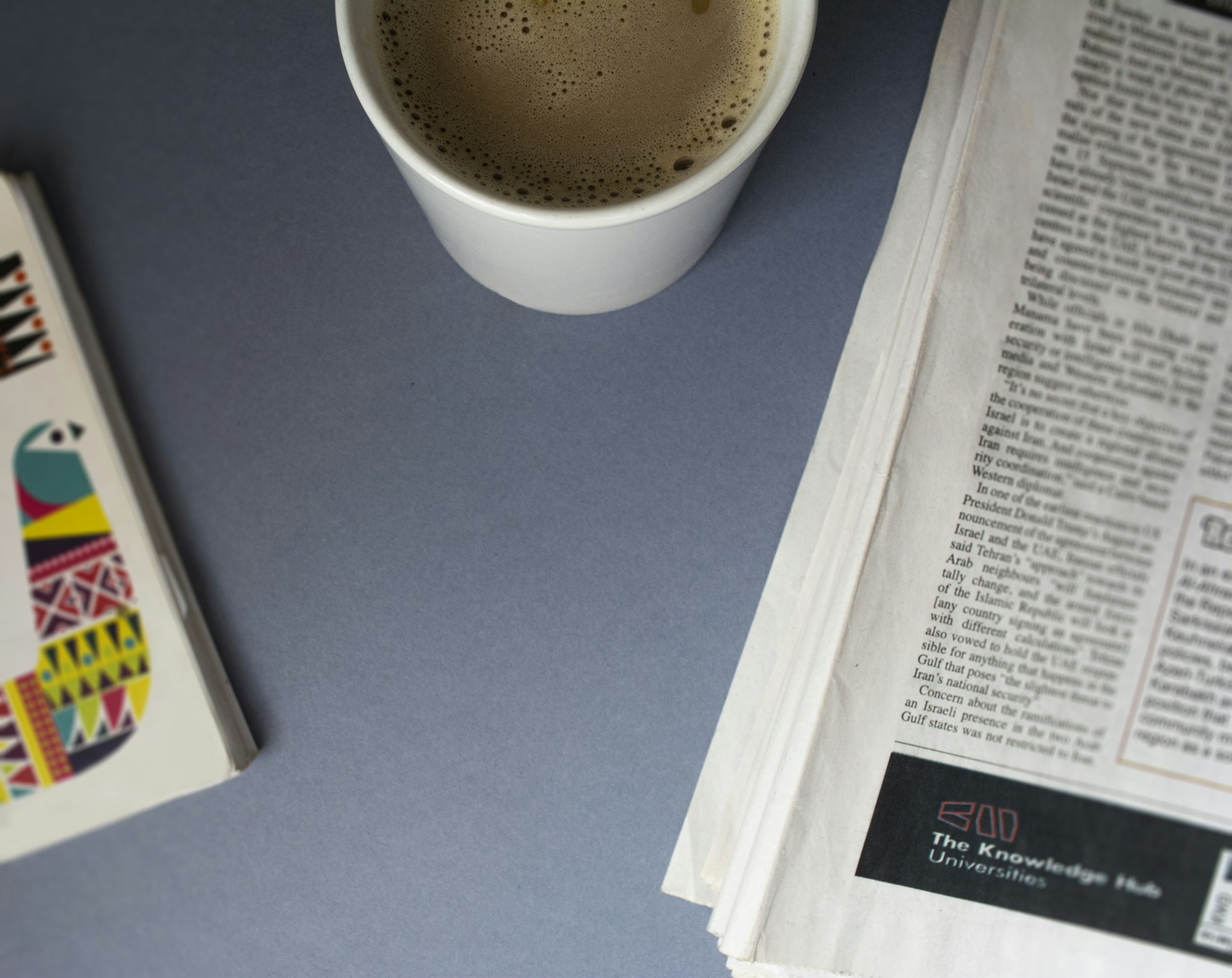 A cup of coffee and a newspaper on a table