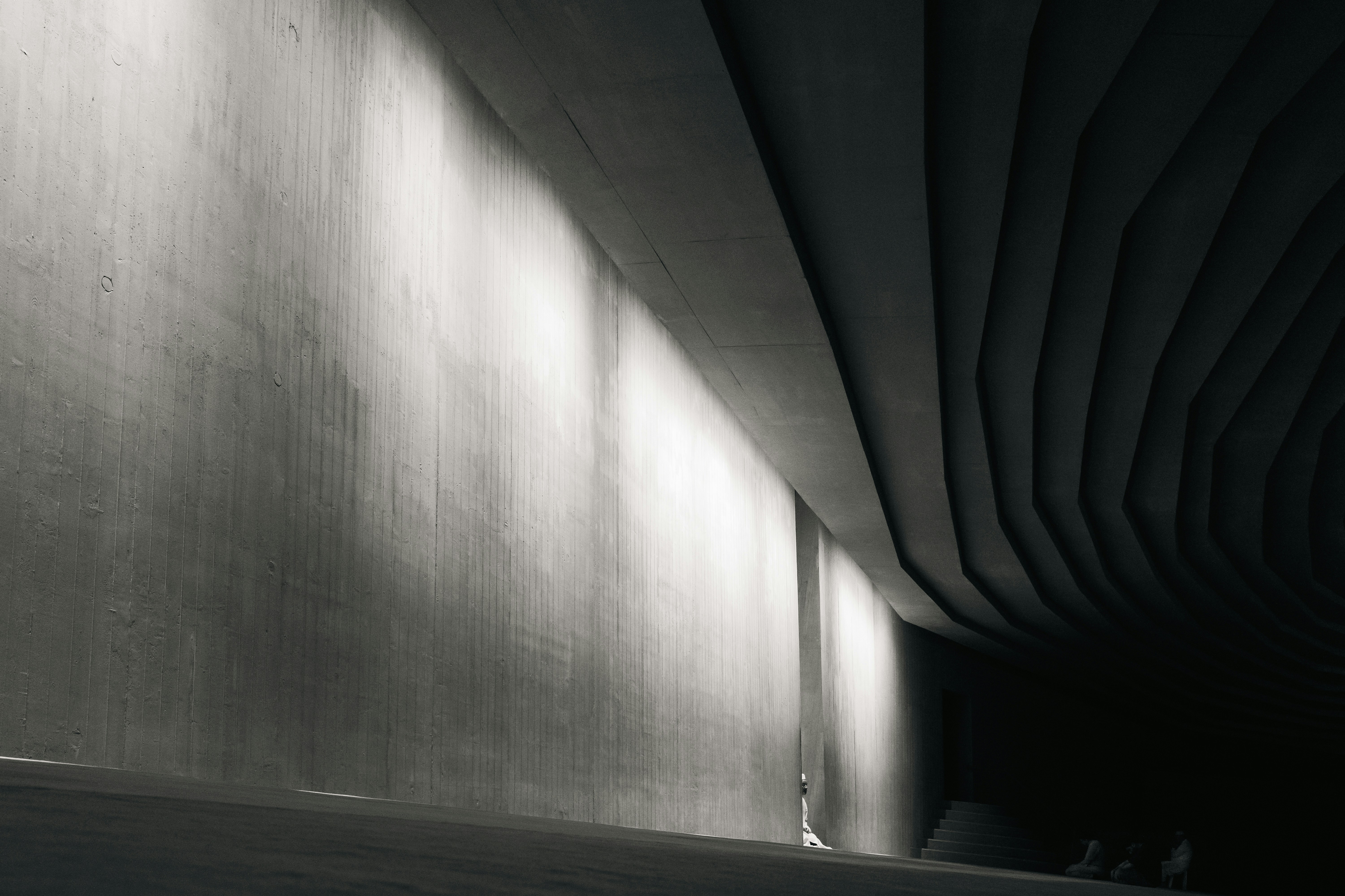 A man riding a skateboard down a street under a bridge