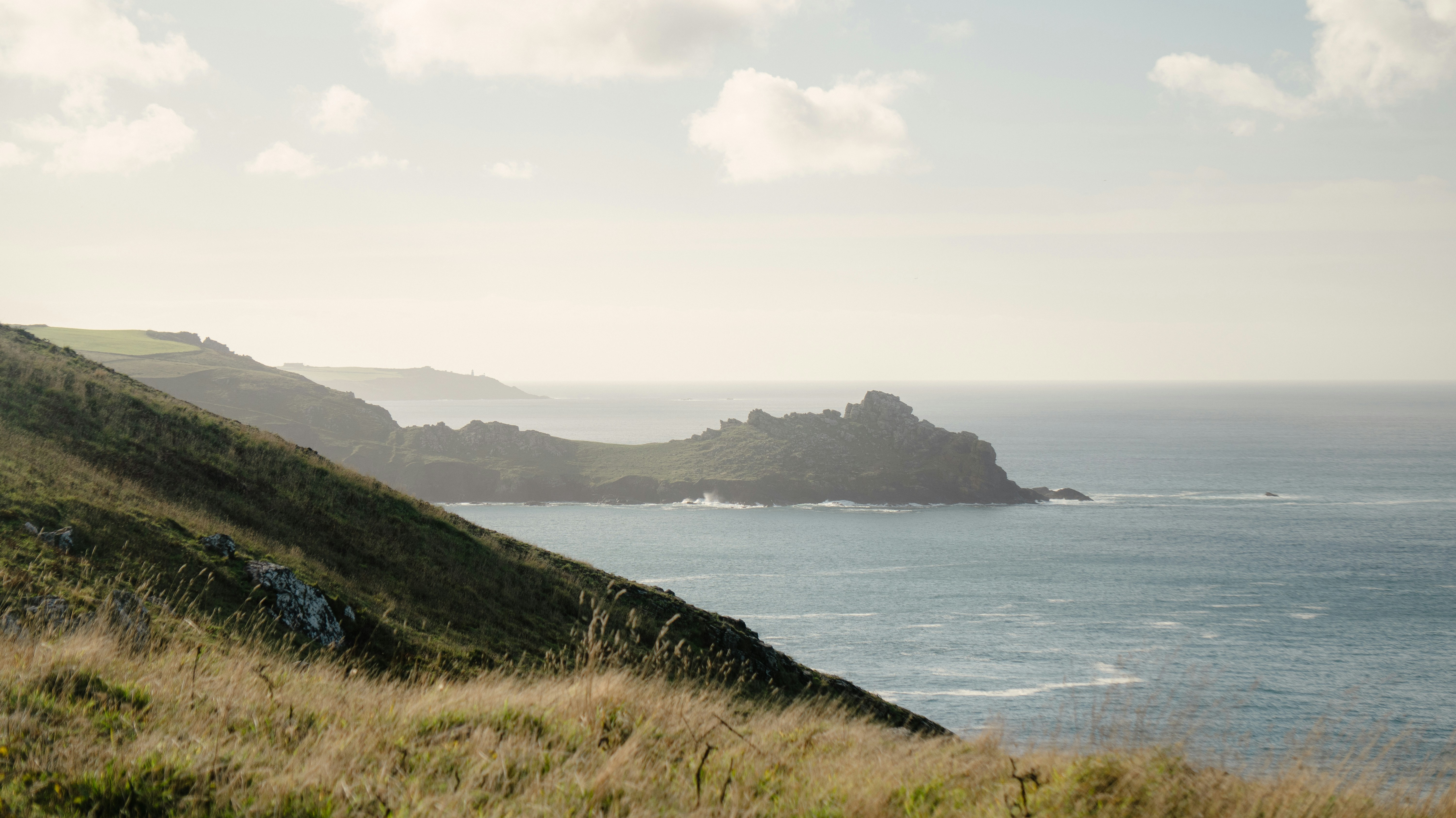 A grassy hill with a body of water in the background