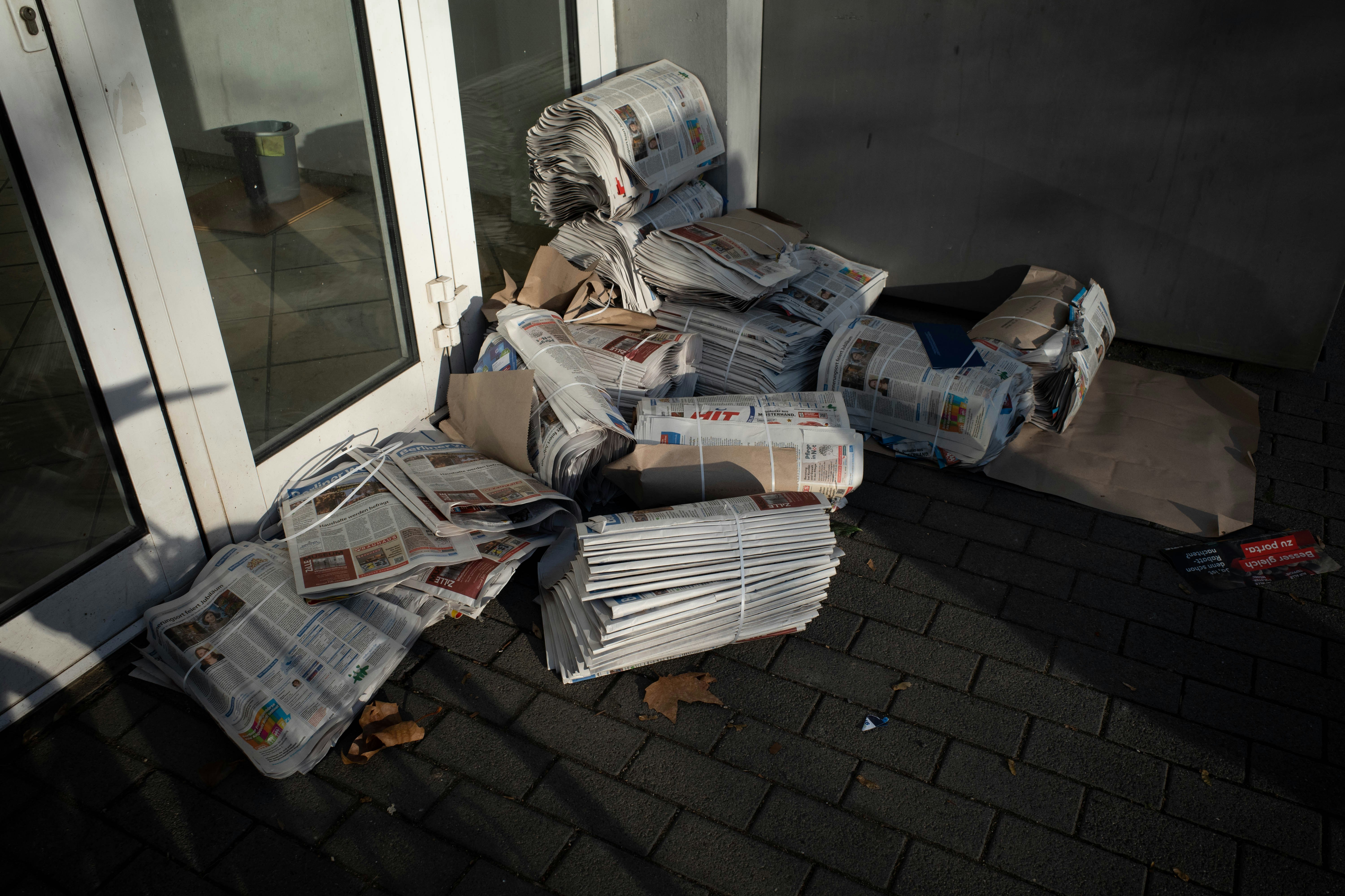A pile of newspapers sitting in front of a window