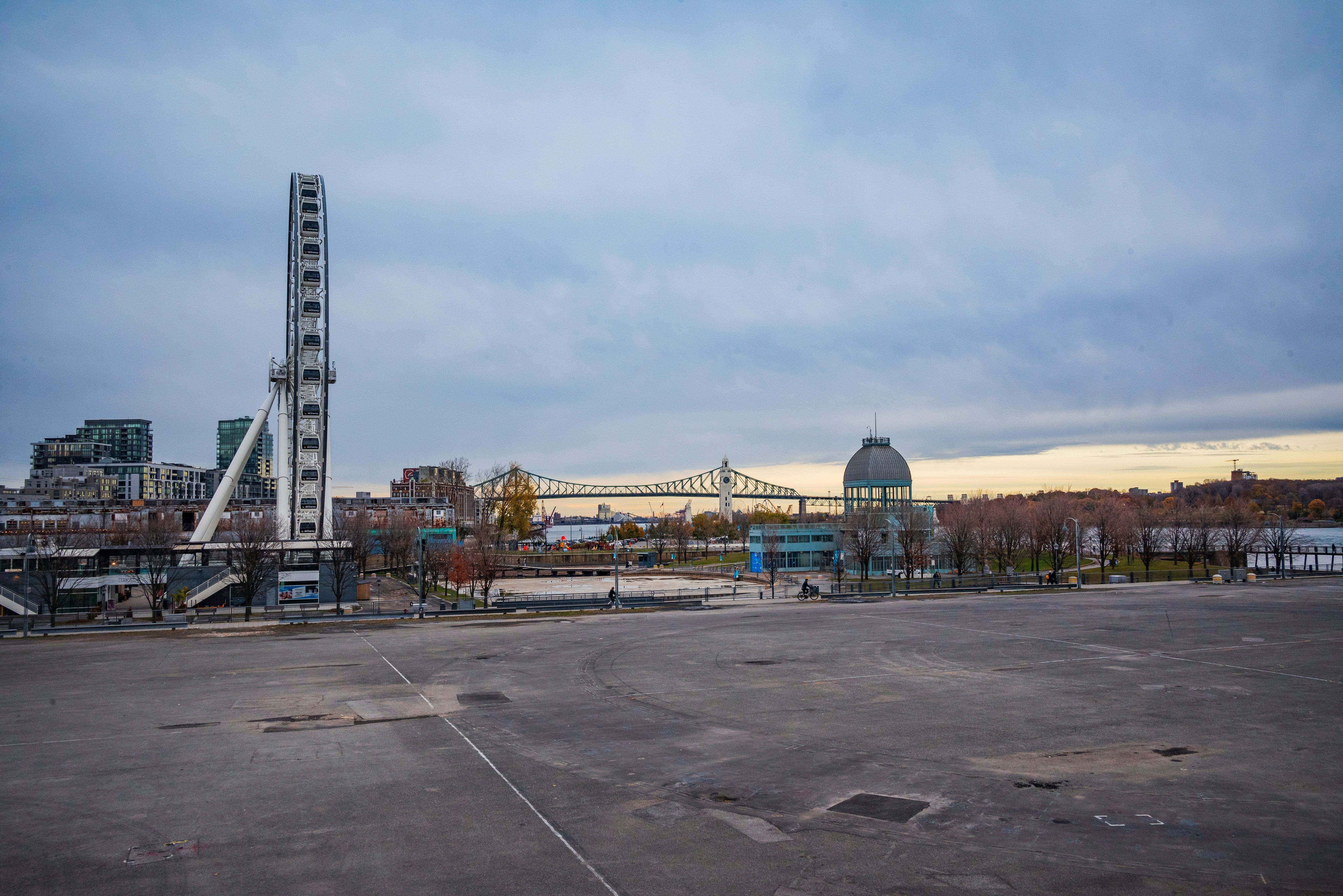 An empty parking lot with a tall tower in the background