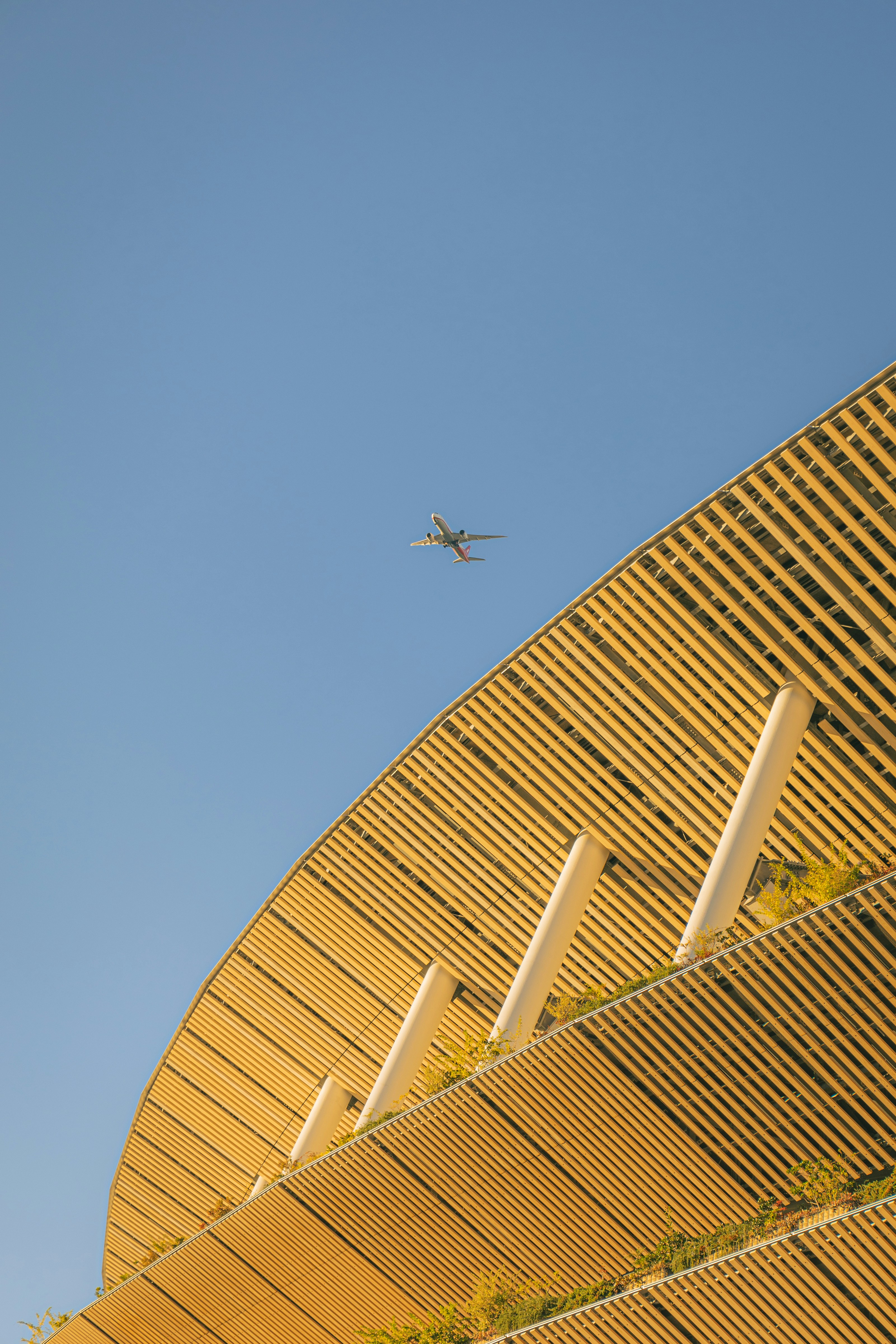 An airplane is flying over a large building