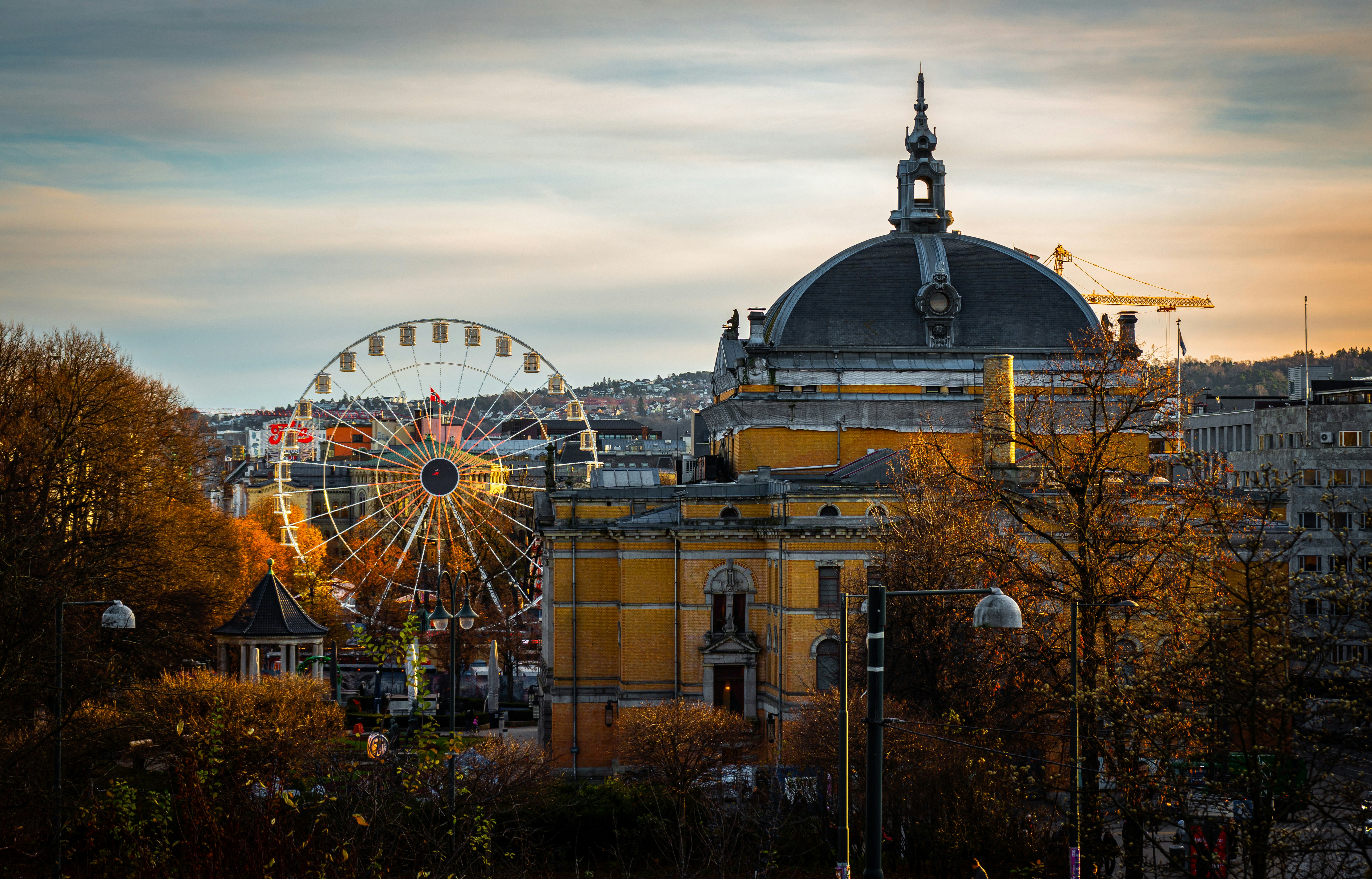 A large building with a ferris wheel in front of it