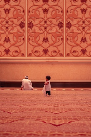 muslim parent and child sitting in masjid