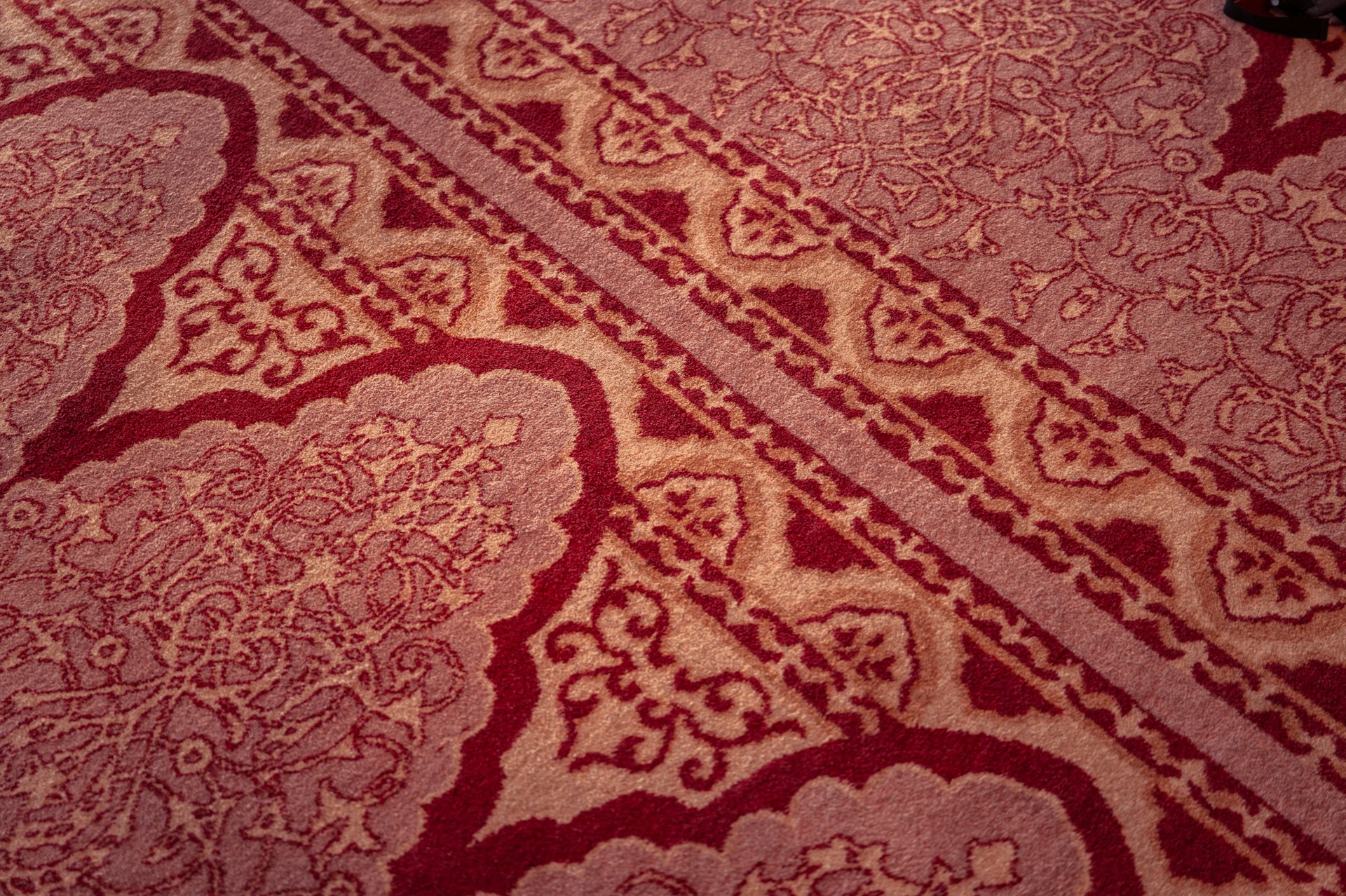 A red and white rug on the floor of a room