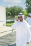 A man walking down a sidewalk while talking on a cell phone