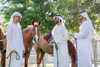 A group of men standing next to a brown horse