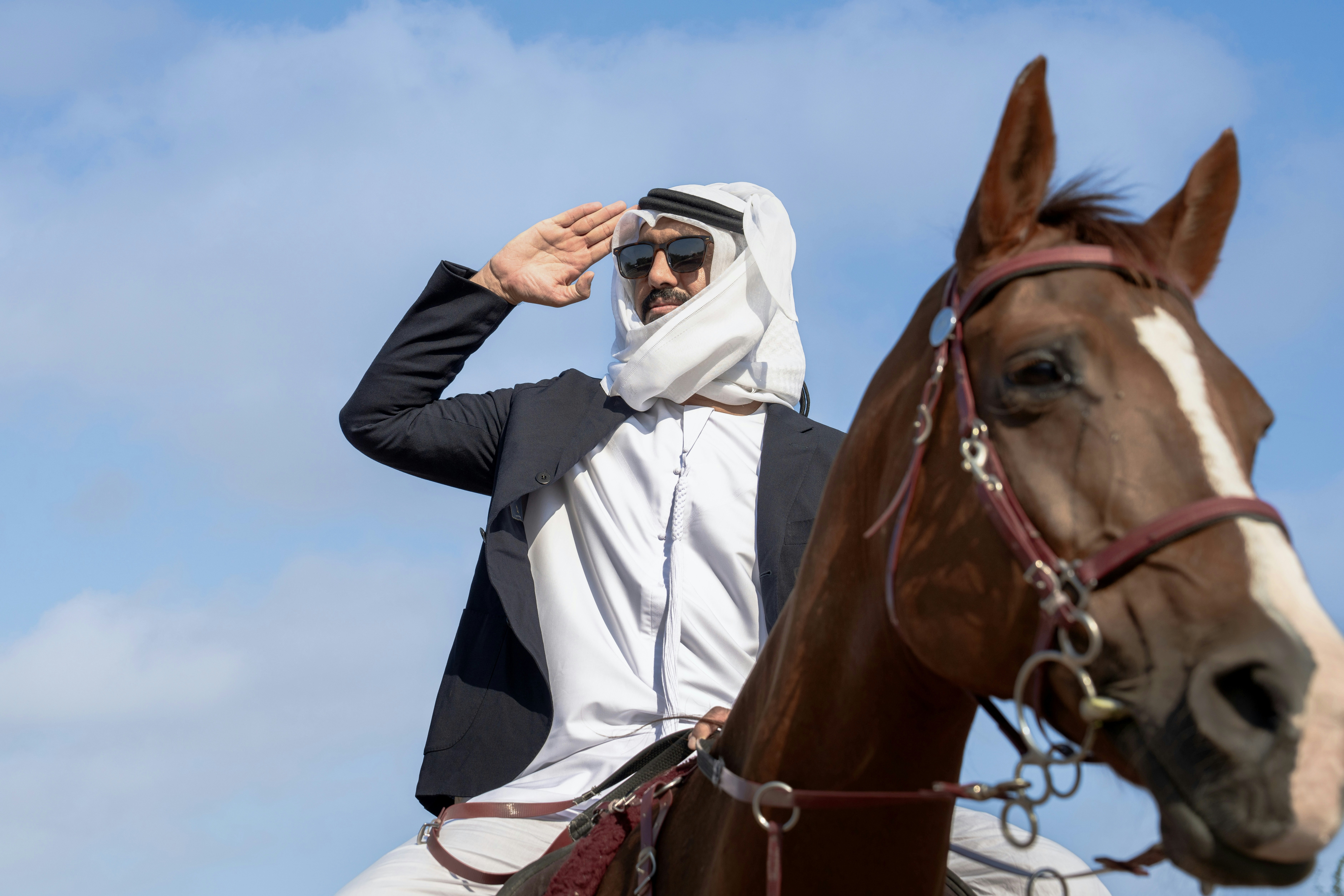 A man in a suit riding a horse