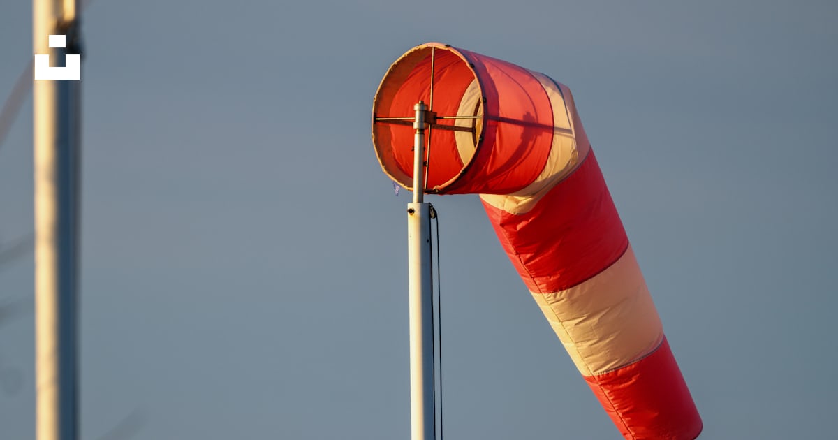 A couple of red and white flags next to a body of water photo – Free ...