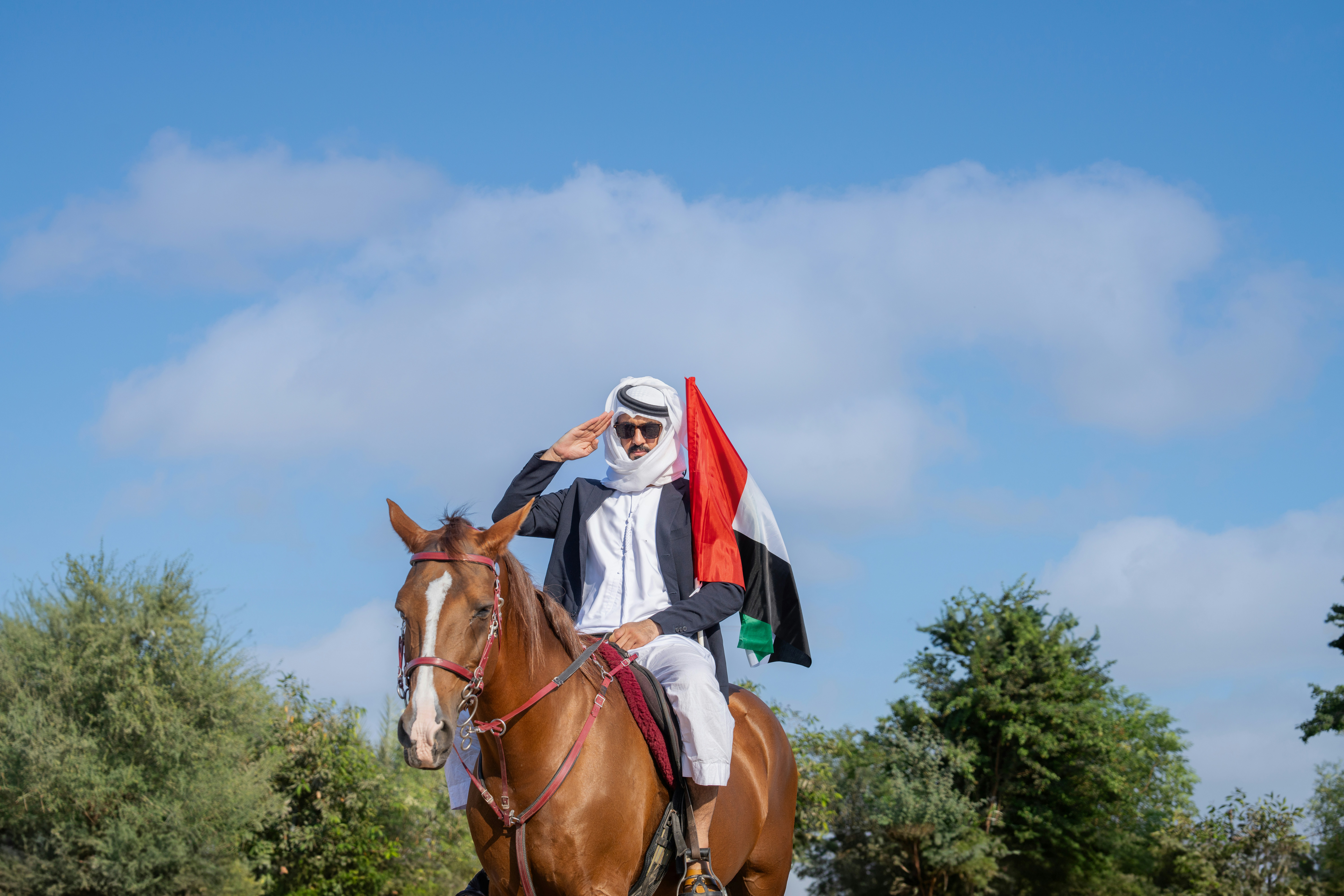 A man riding on the back of a brown horse