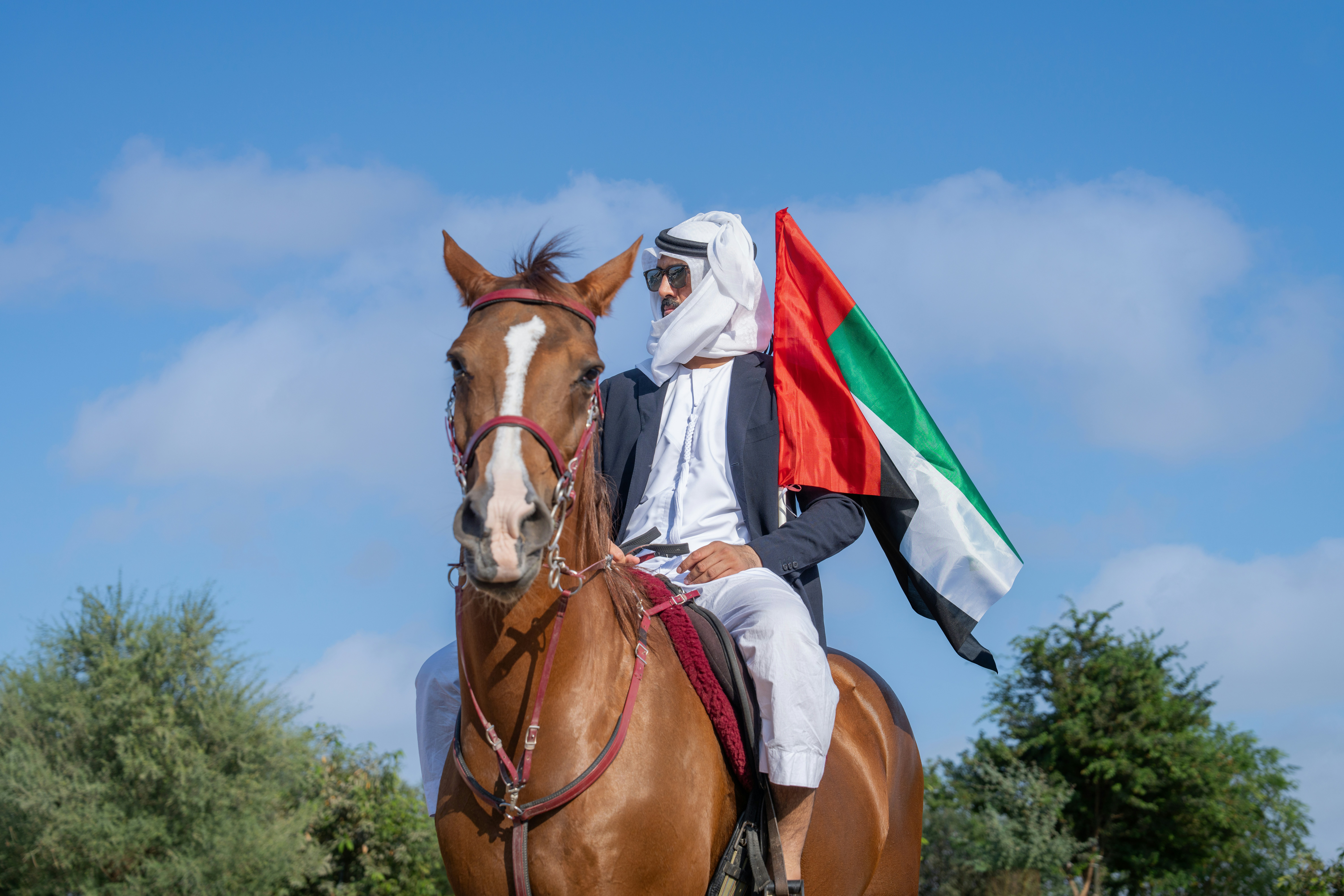 A man riding on the back of a brown horse