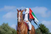 A man riding on the back of a brown horse