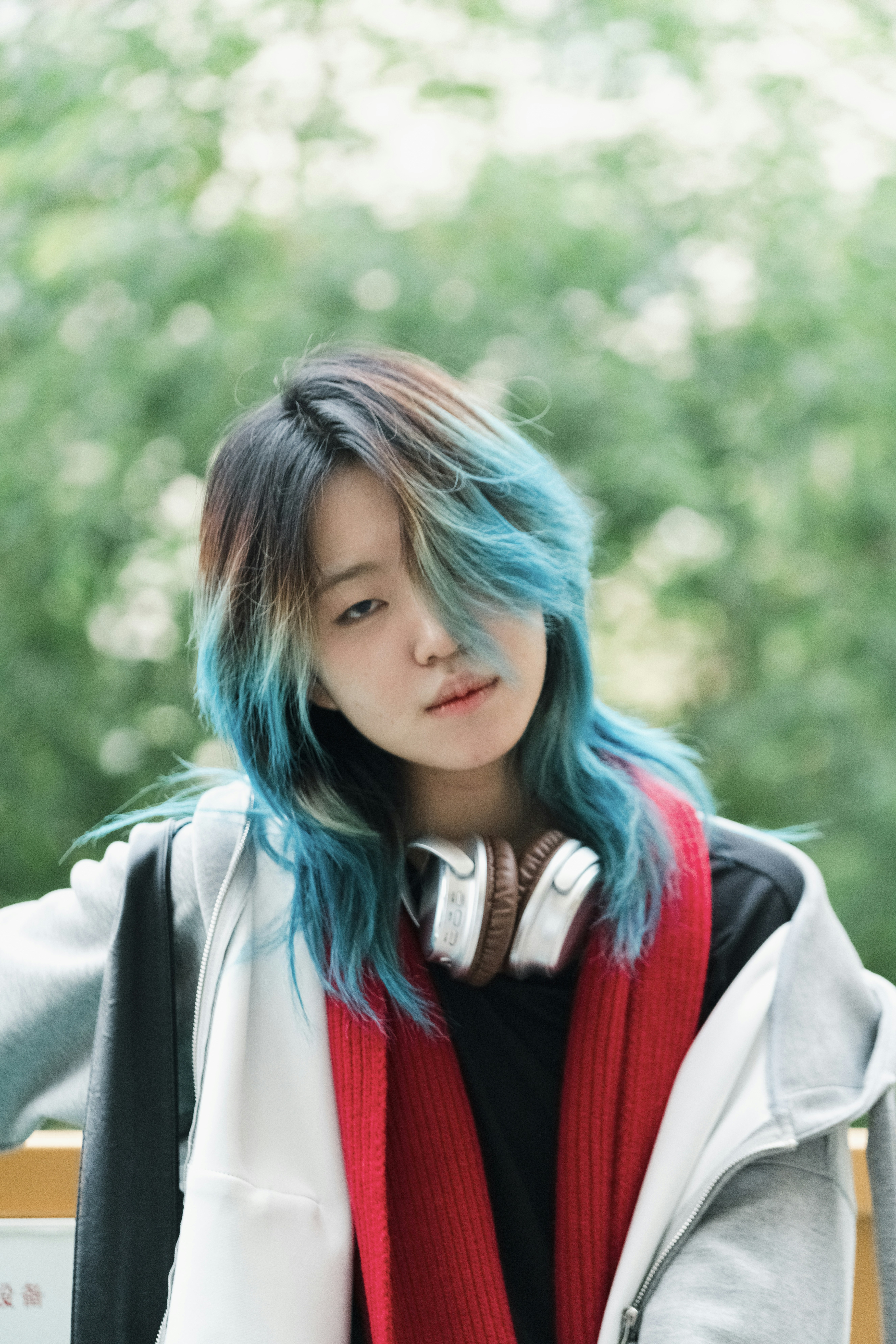 Seorang wanita muda dengan rambut biru dan headphone