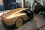 A gold colored car on display in a building