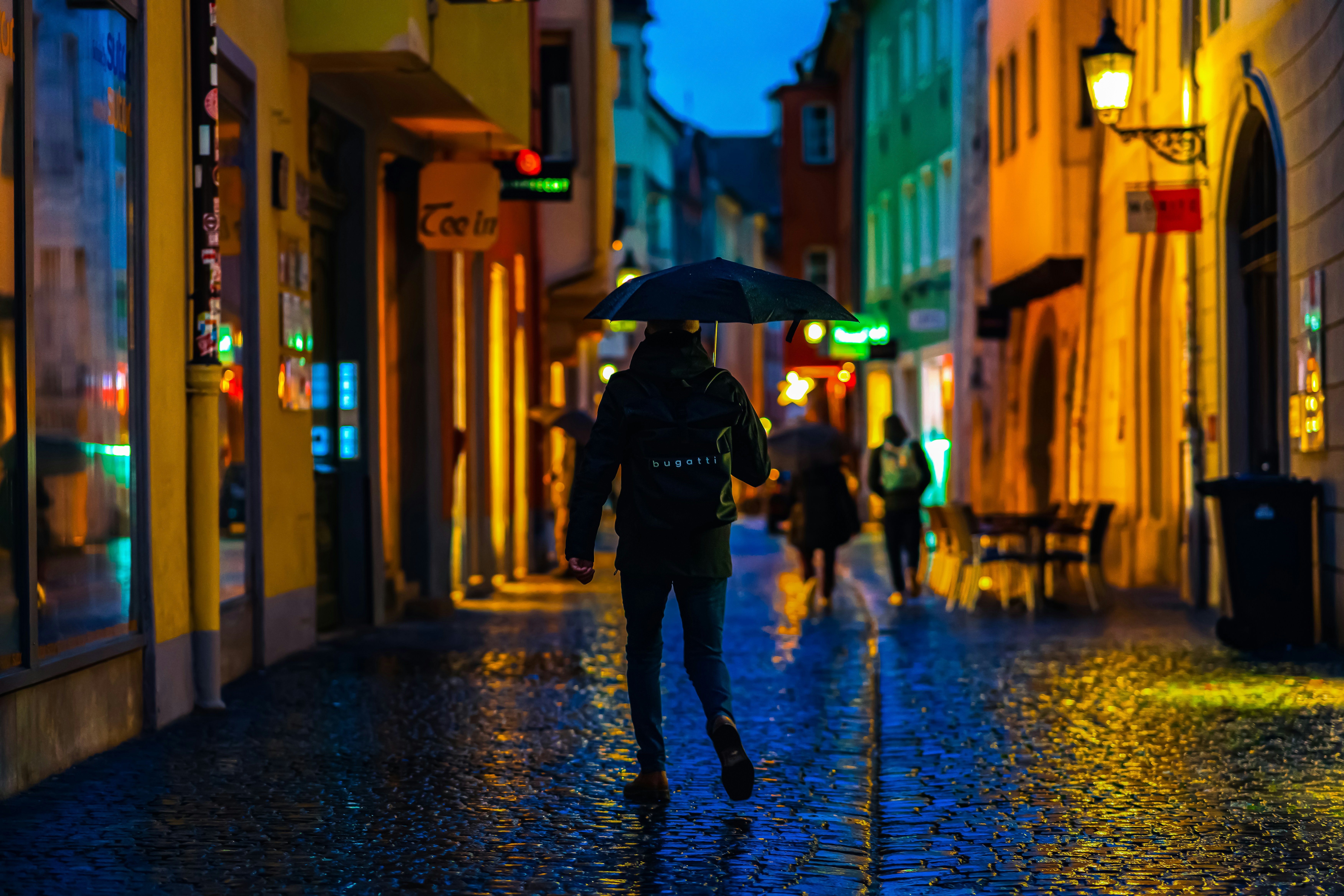 A person walking down a street holding an umbrella