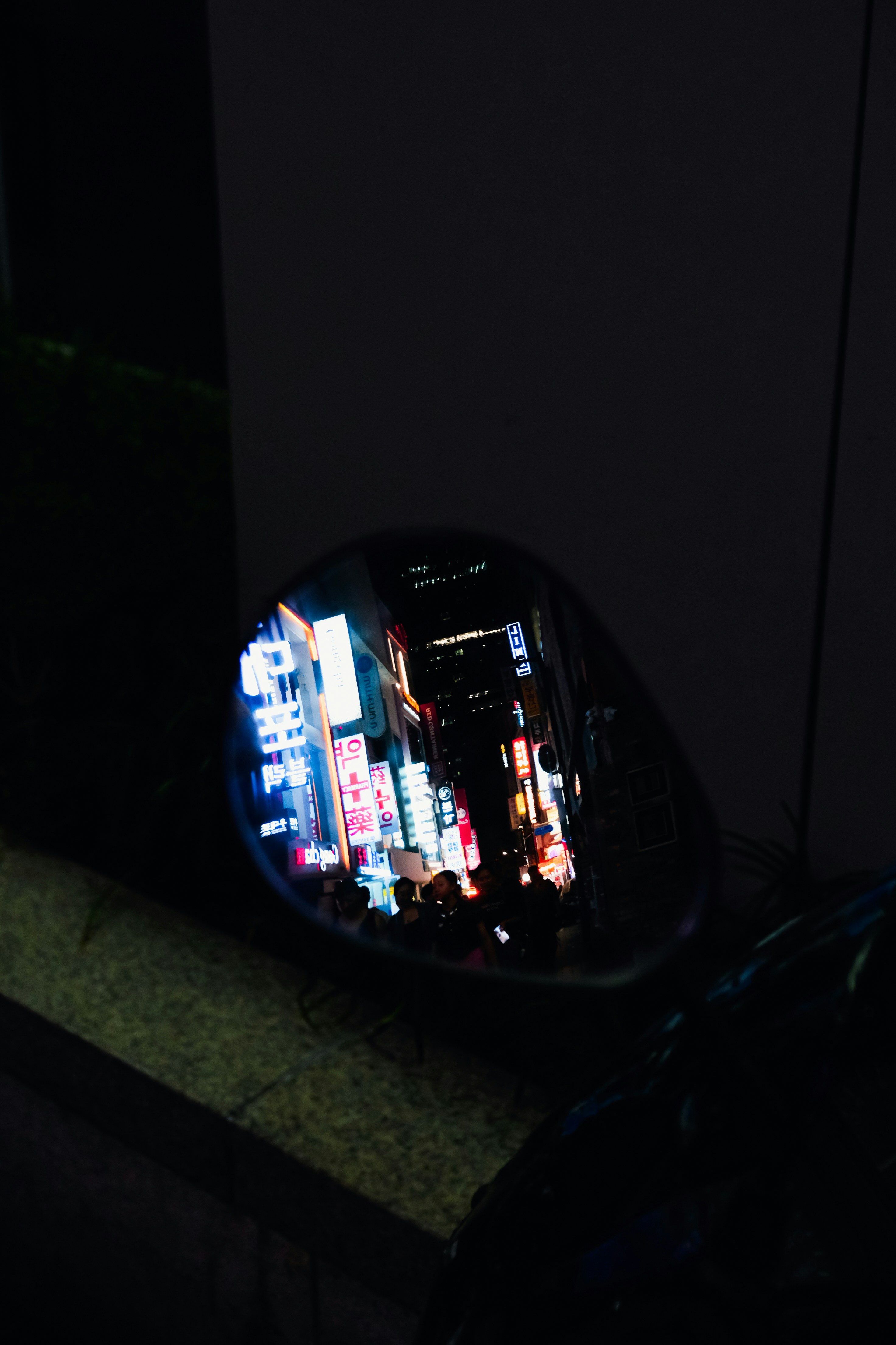 A rear view mirror sitting on the side of a building