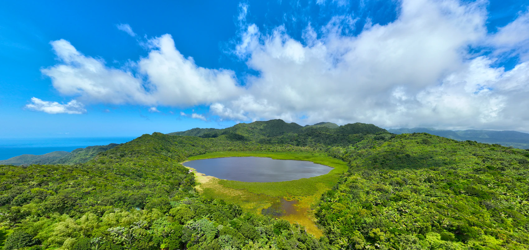 Grand Etang crater lake surrounded by dense green forest in Grenada's central highlands