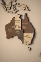 A wooden map of australia on a white wall