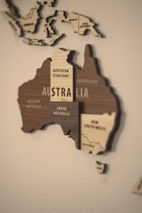 A wooden map of australia on a white wall