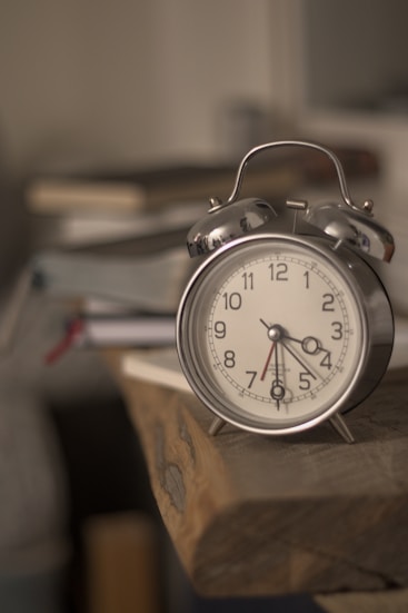 An alarm clock sitting on top of a wooden block