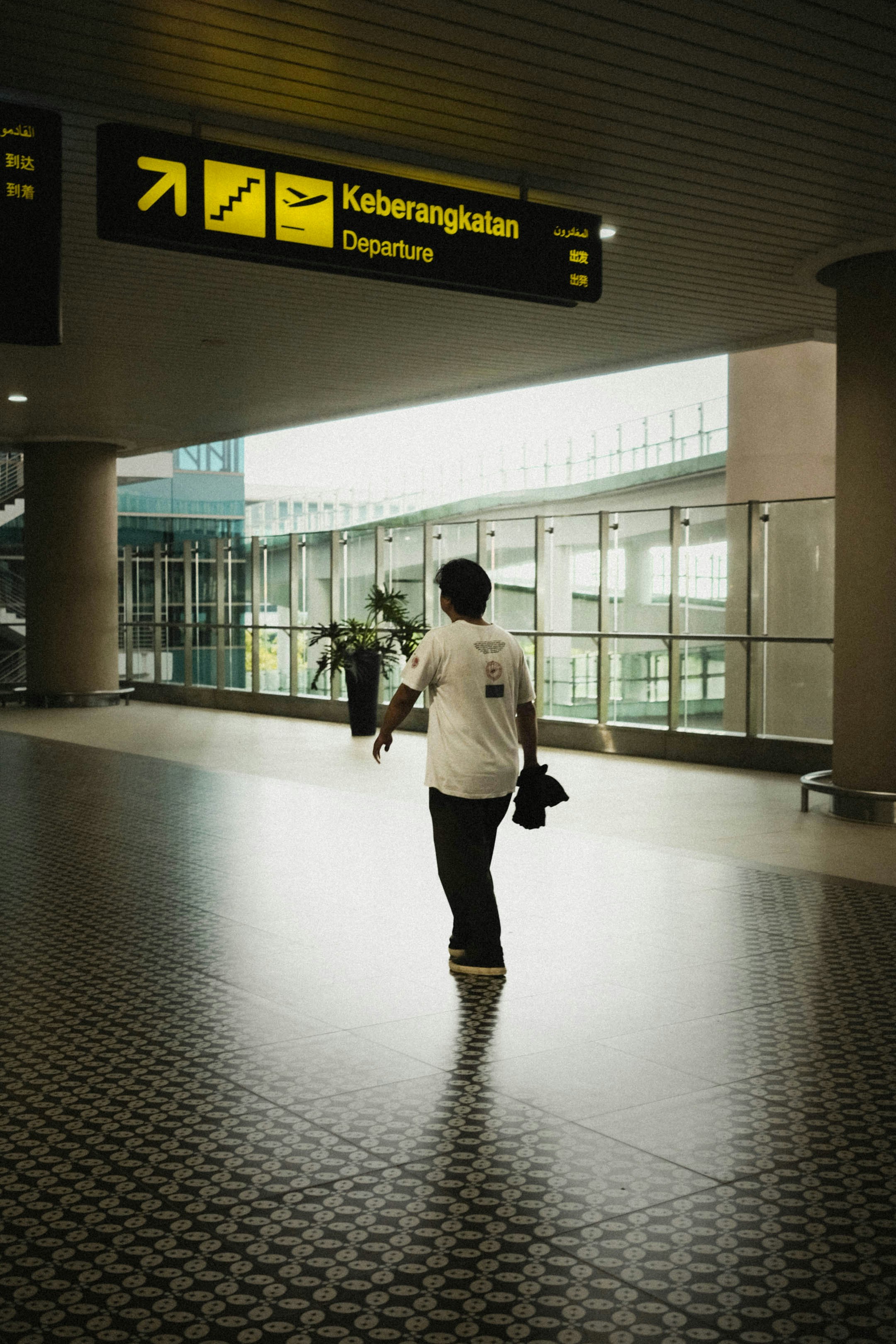 A man walking through an airport terminal at night