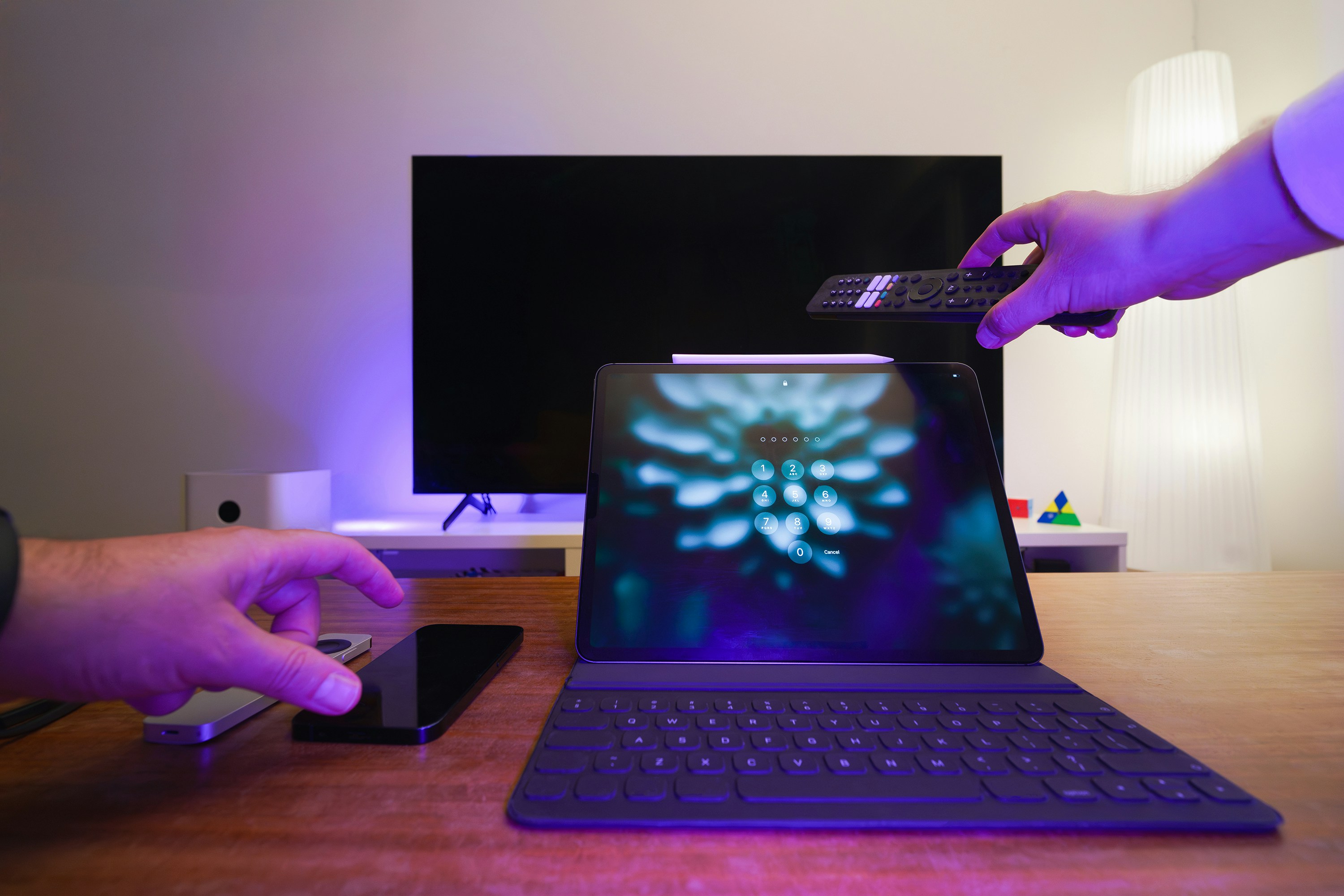 A person is holding a remote control over a laptop