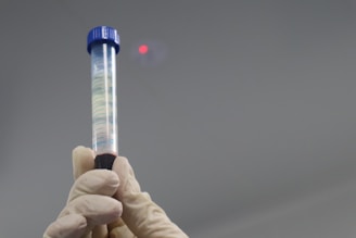 A person holding a tube with a liquid inside of it