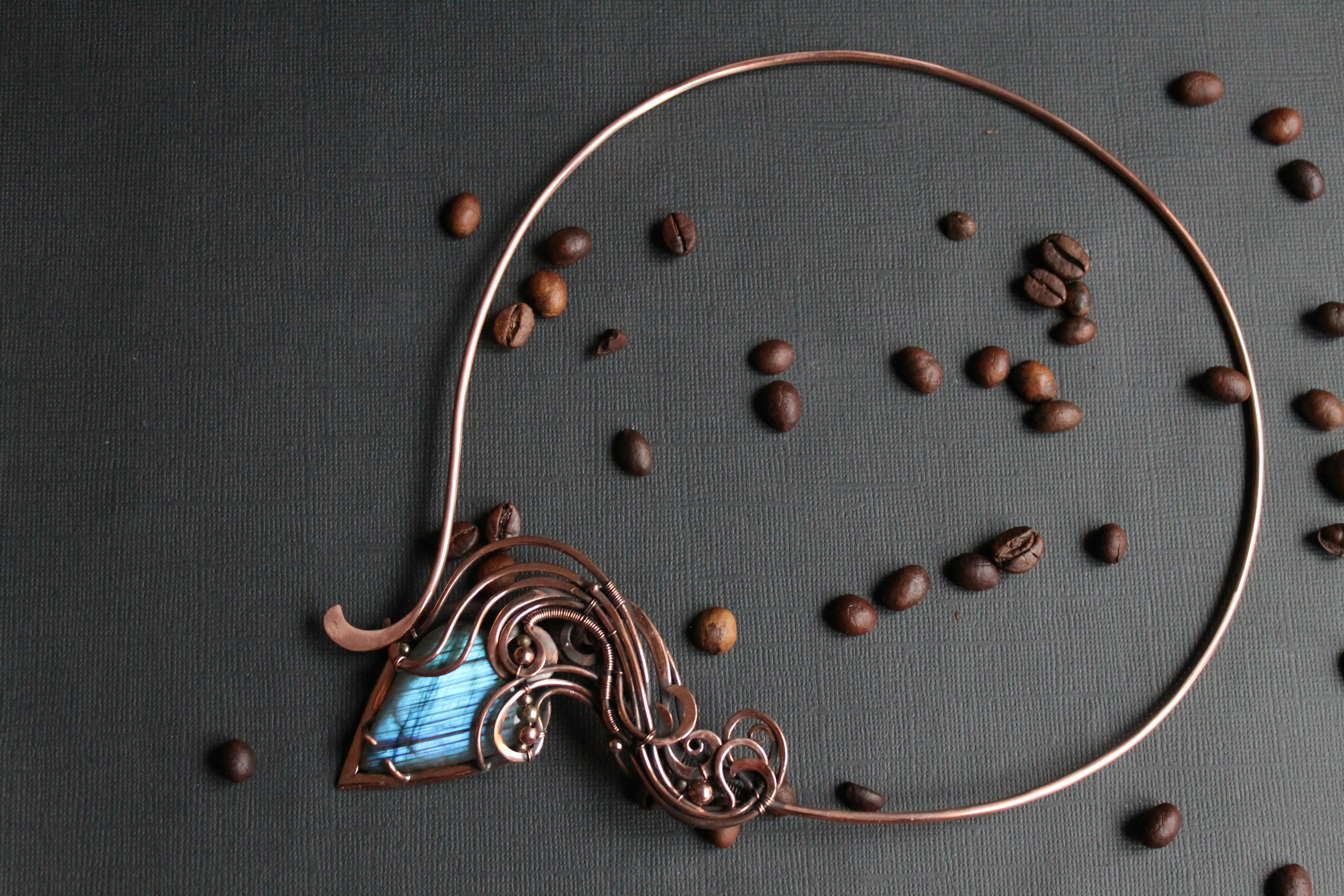 A necklace with a blue stone in the middle surrounded by coffee beans