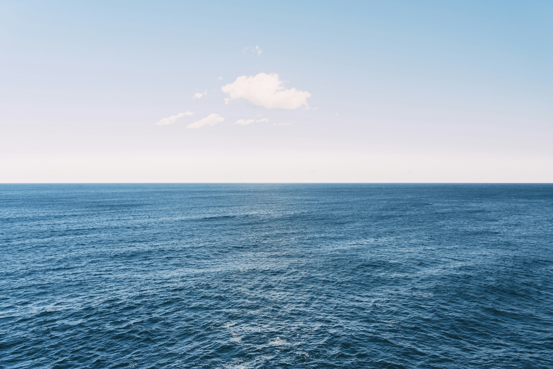A large body of water with a cloud in the sky
