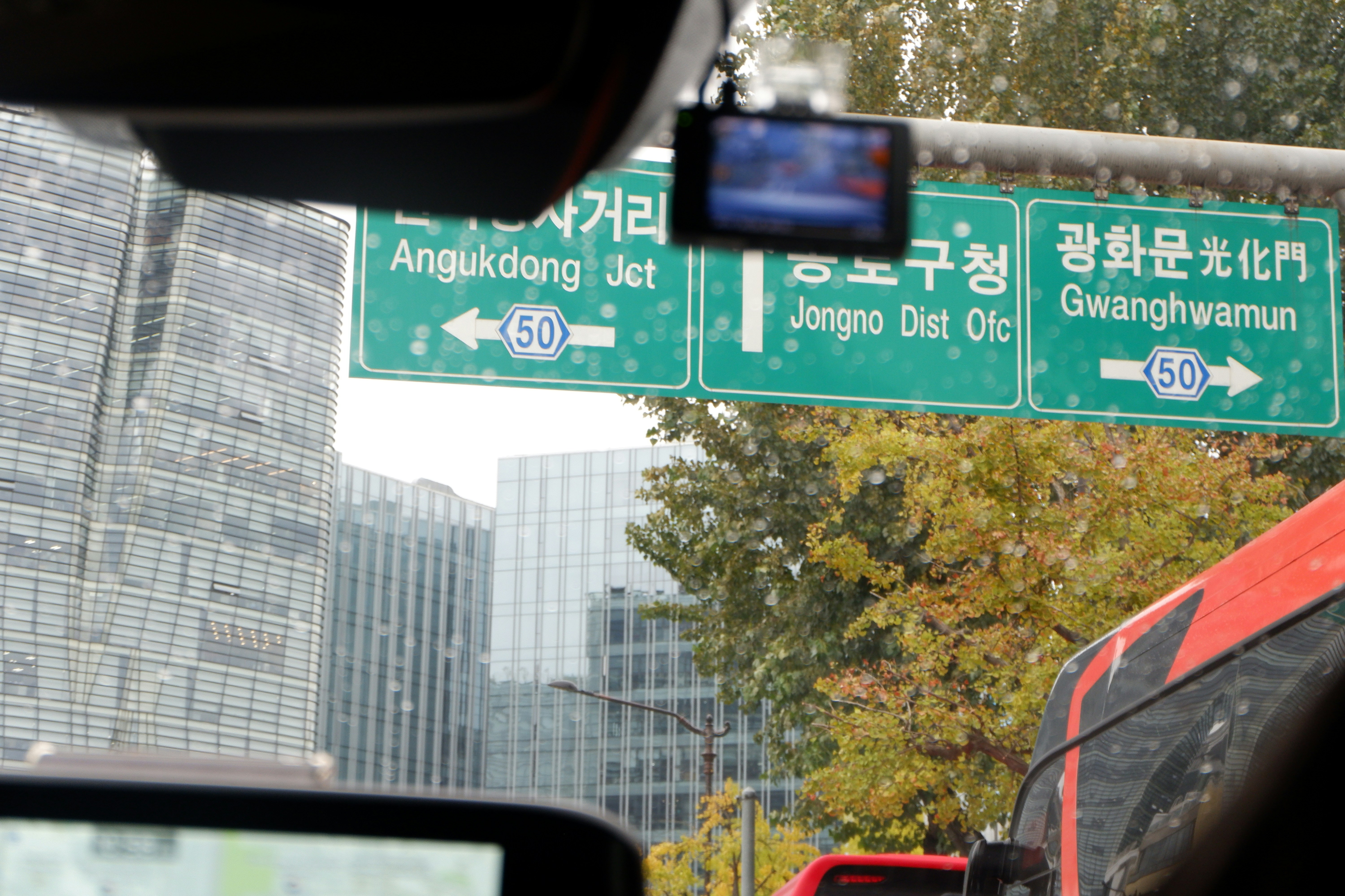 Ein grünes Straßenschild, das an der Seite einer Ampel hängt